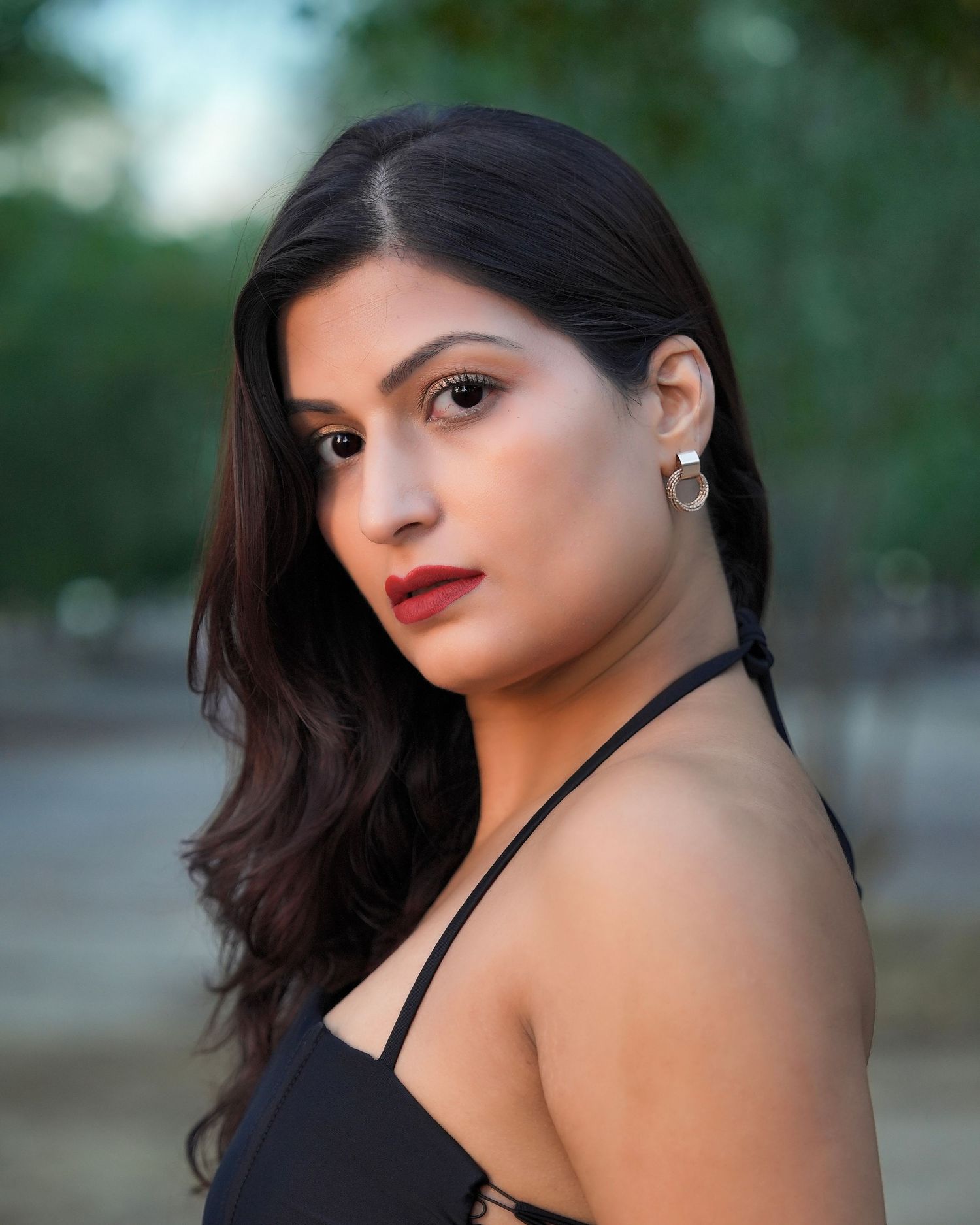 Portrait photo series showing a woman in a black top posing outdoors with dramatic lighting and red lipstick.