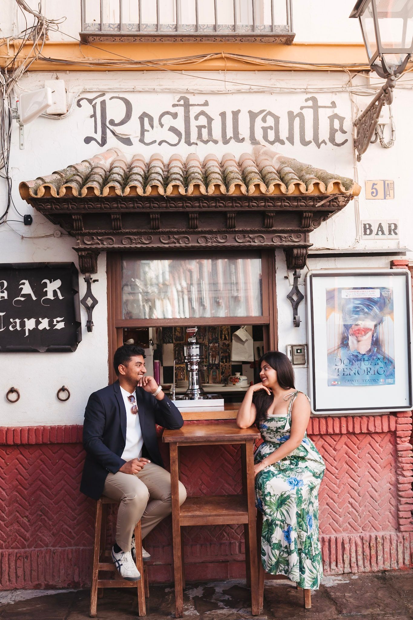 Couple sitting outside a traditional Spanish tapas bar and restaurant in Seville.