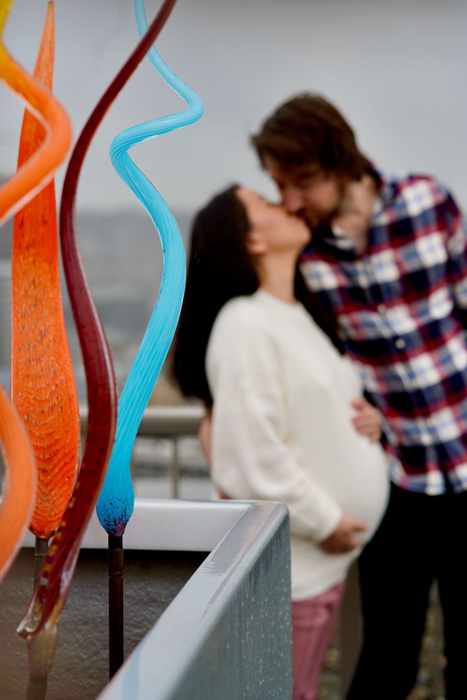 Couple sharing a kiss on a rooftop during a maternity photography session in Port Townsend, Washington