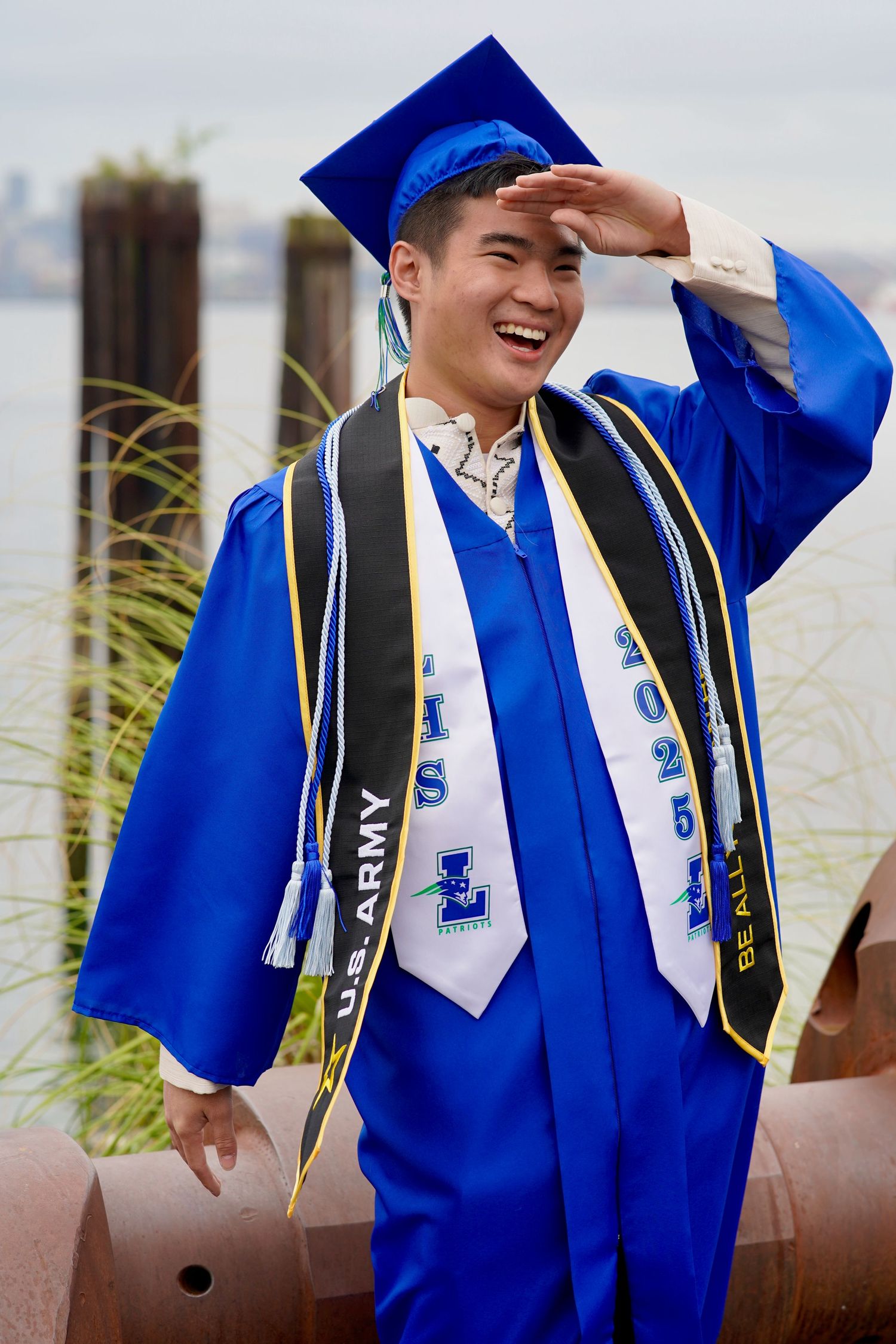 High school graduate celebrating with cap and gown during a graduation photo session in Port Townsend, Washington