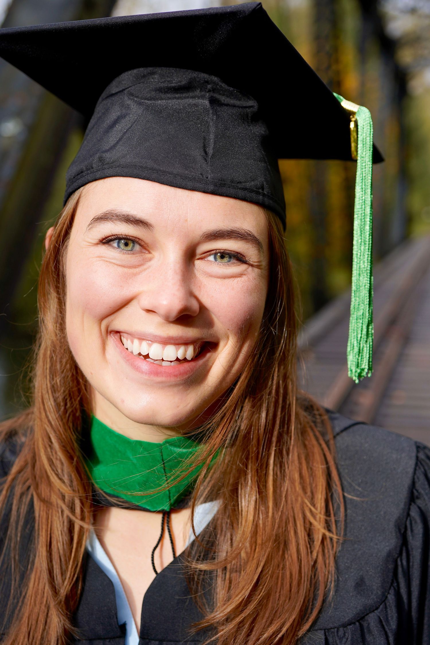 College graduate celebrating with cap and gown during a graduation photo session in Port Townsend, Washington