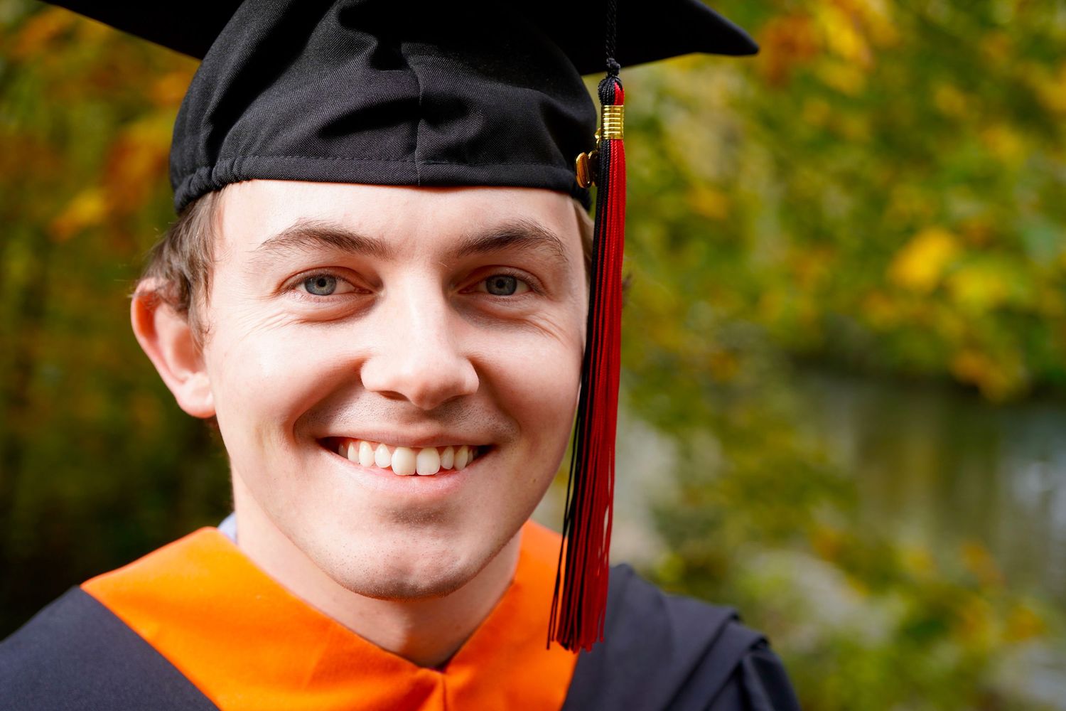 College graduate celebrating with cap and gown during a graduation photo session in Port Townsend, Washington
