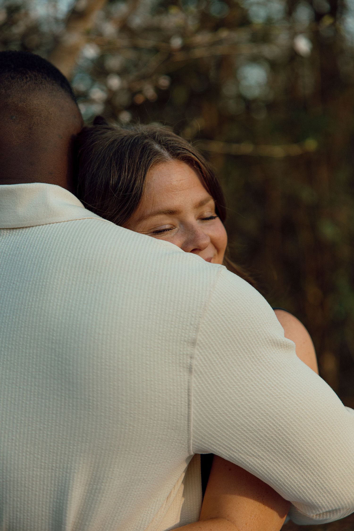 close-up of a couple embracing during an outdoor engagement session