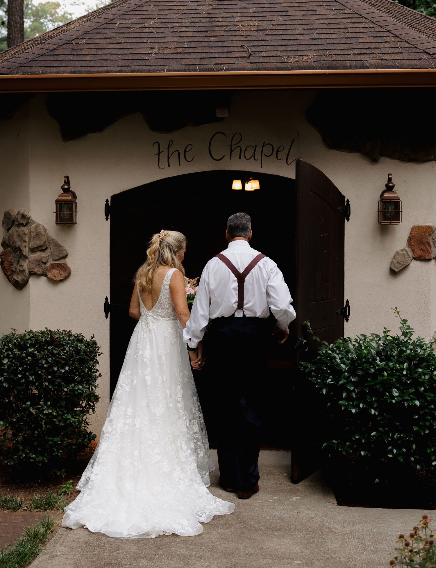 Bride and groom walking hand in hand toward a small wedding chapel