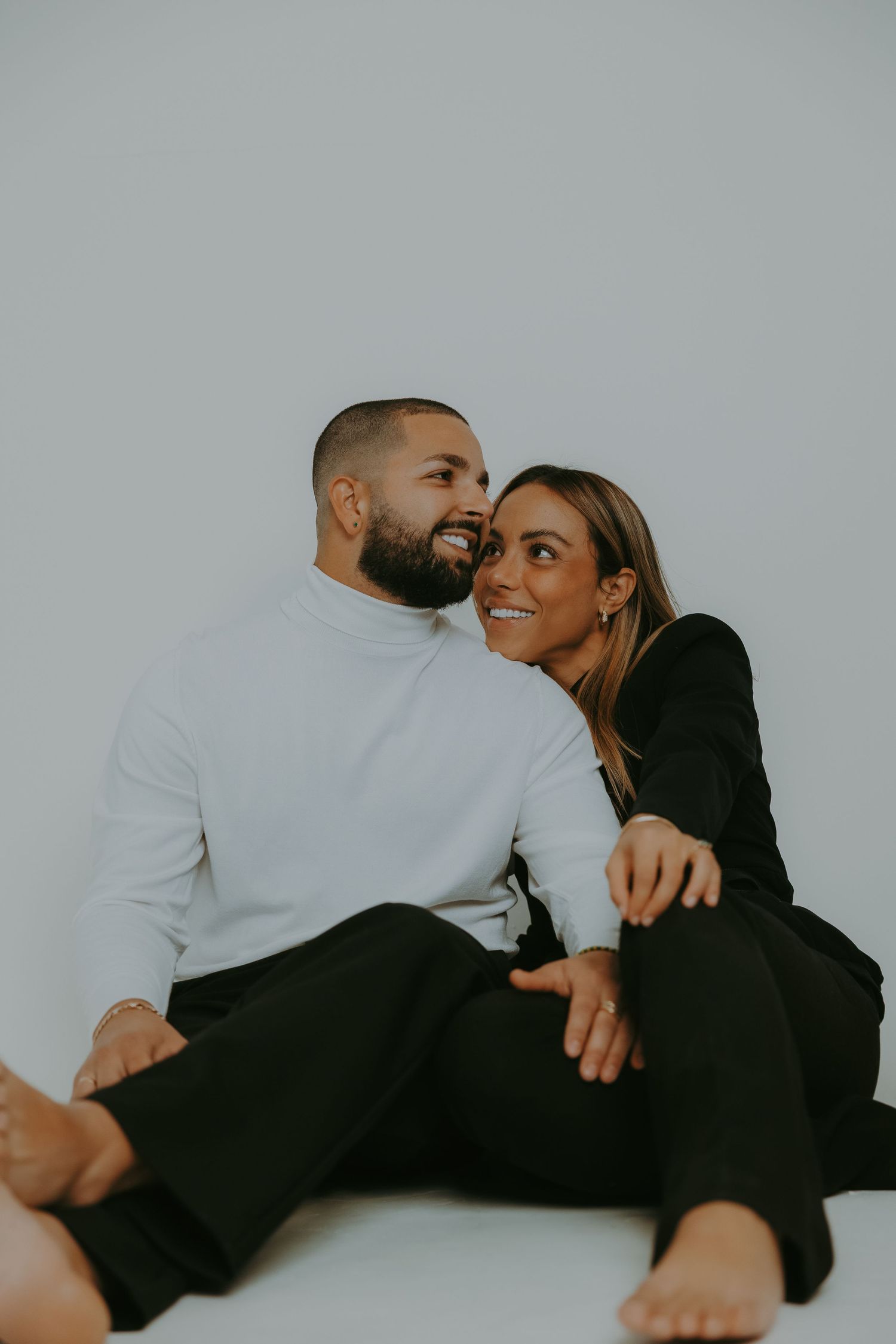 Couple sitting close together during an editorial studio portrait session