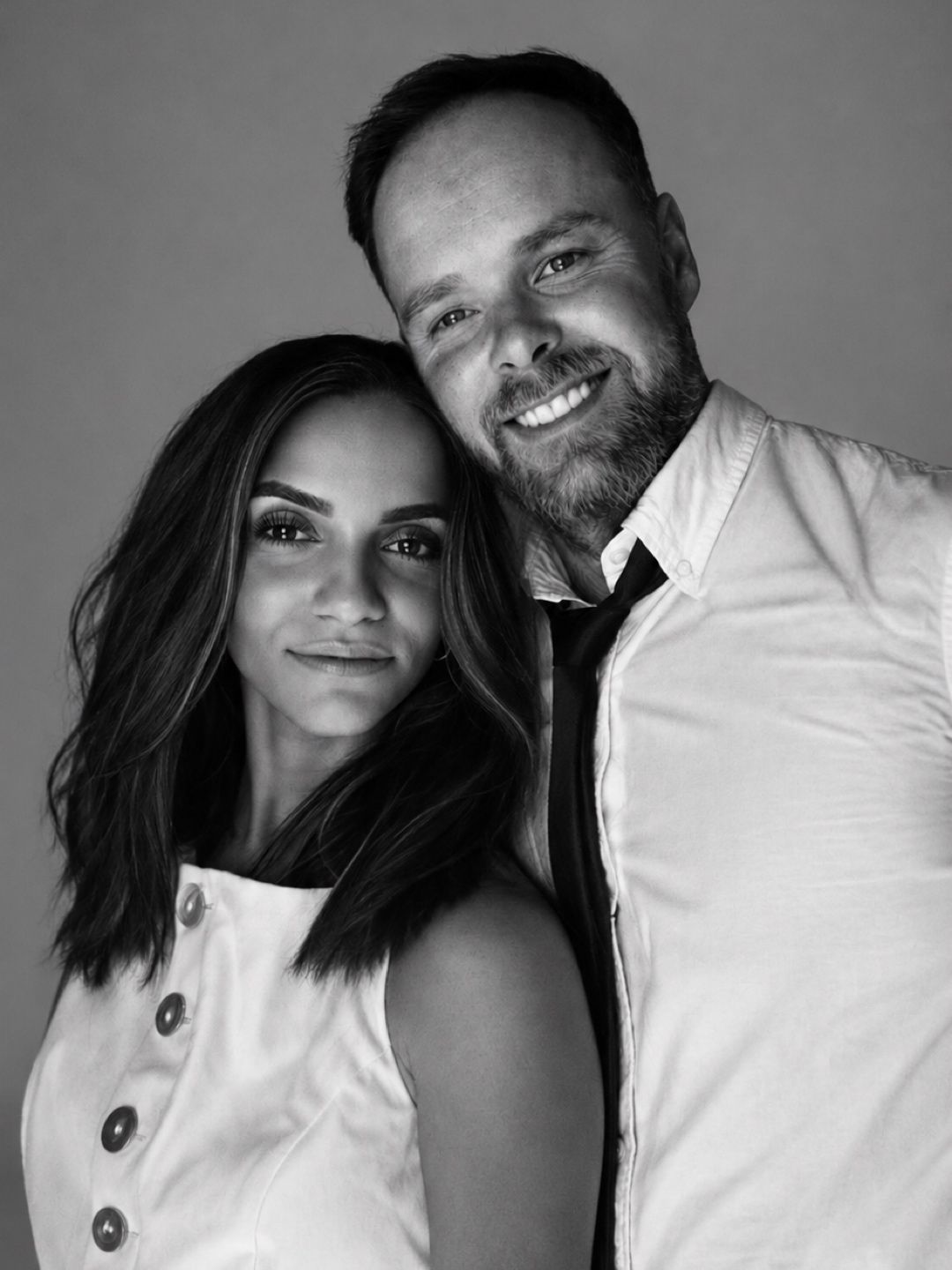 Black and white portrait of a husband-and-wife photography team standing together