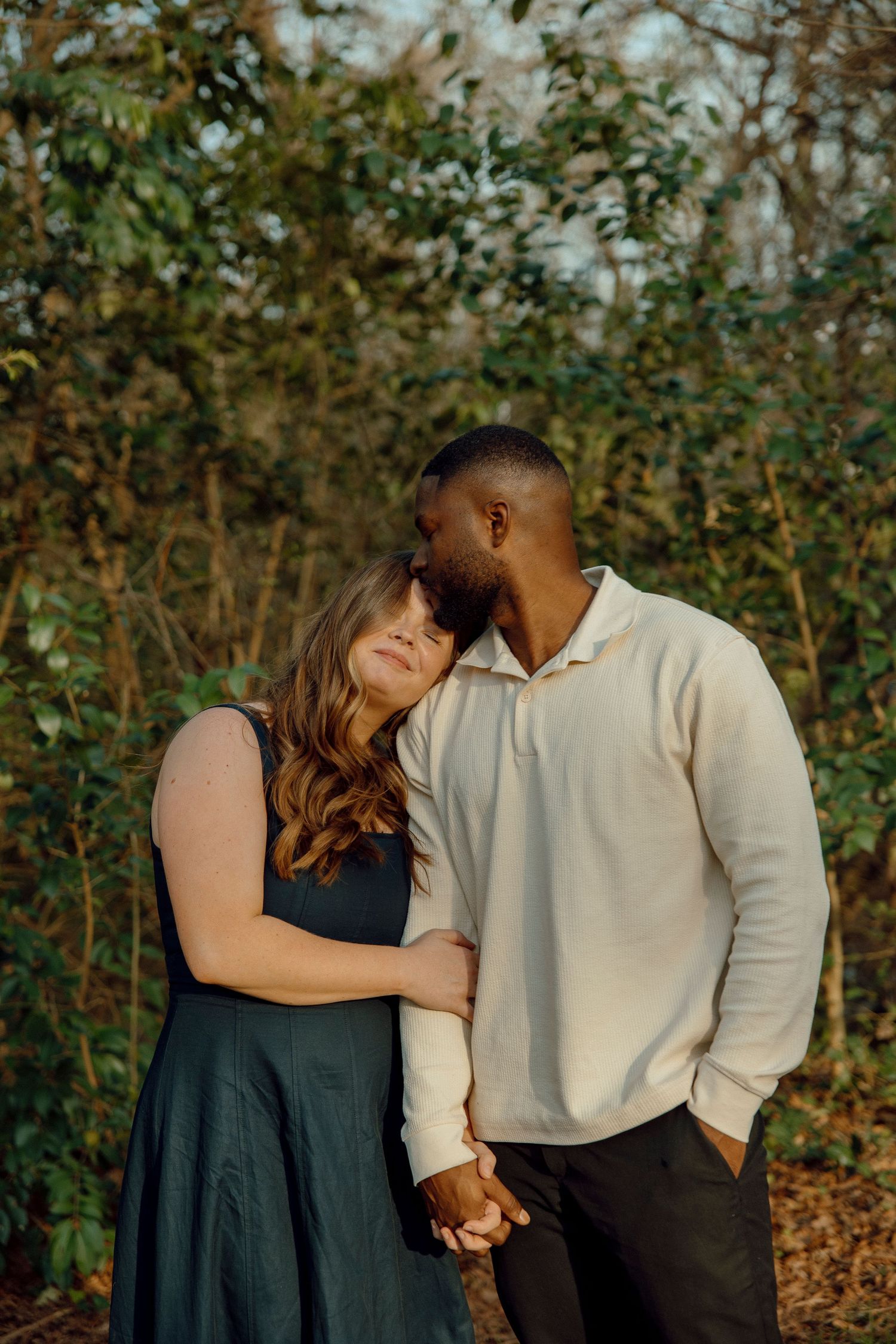 Couple embracing outdoors during a relaxed engagement session