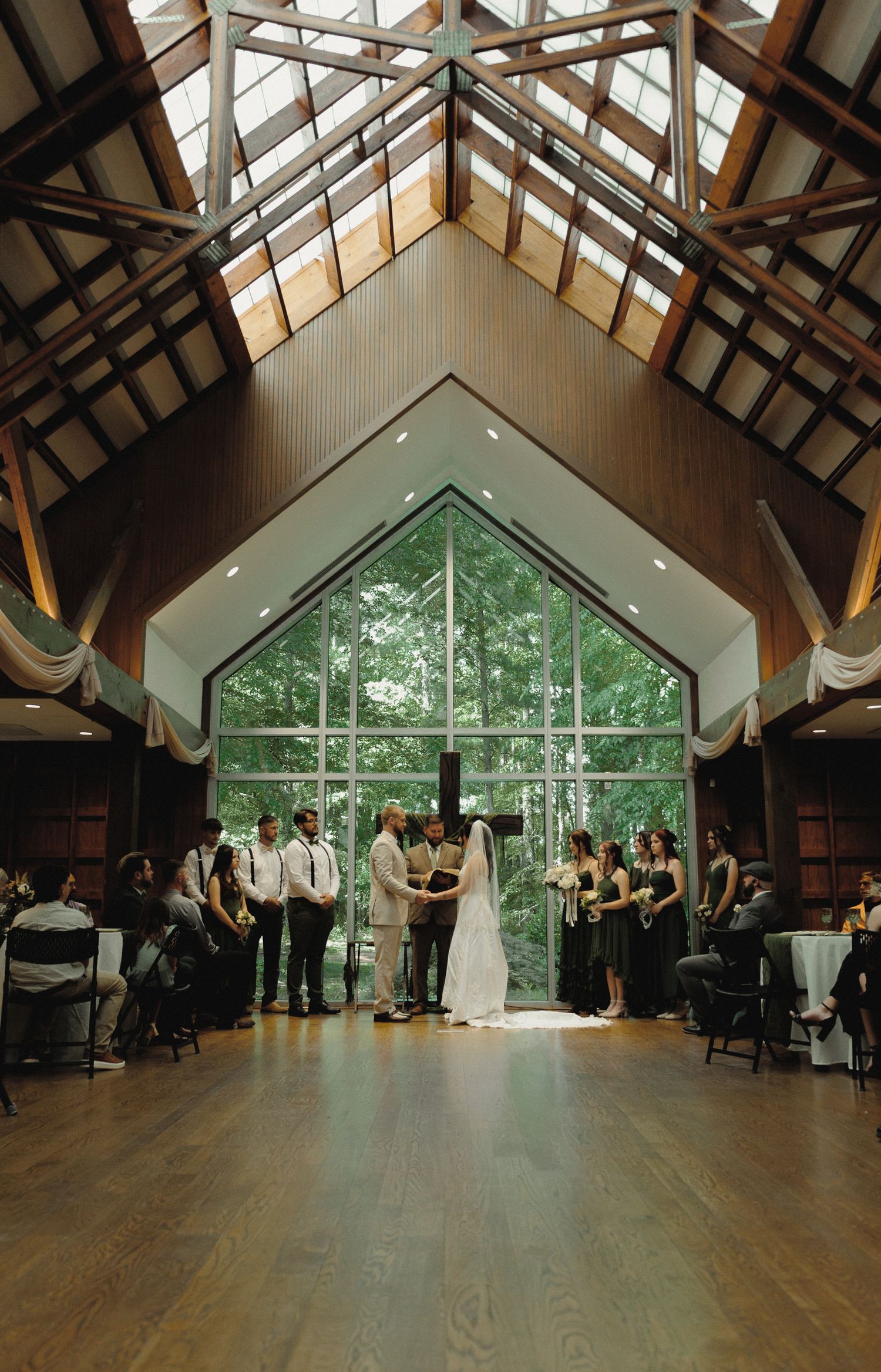 edding ceremony inside a modern chapel with tall windows and wood-beamed ceilings