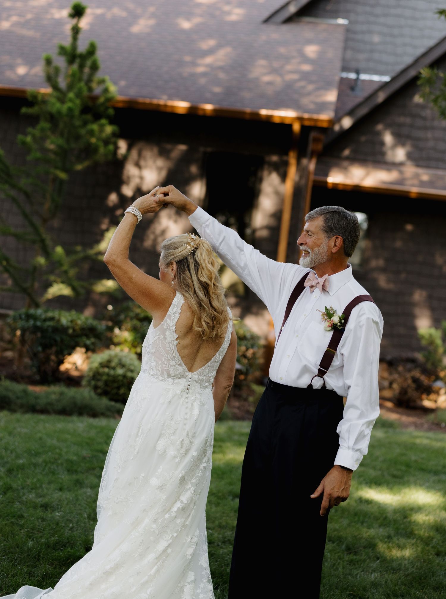 Bride twirling with a husband during an outdoor wedding celebration
