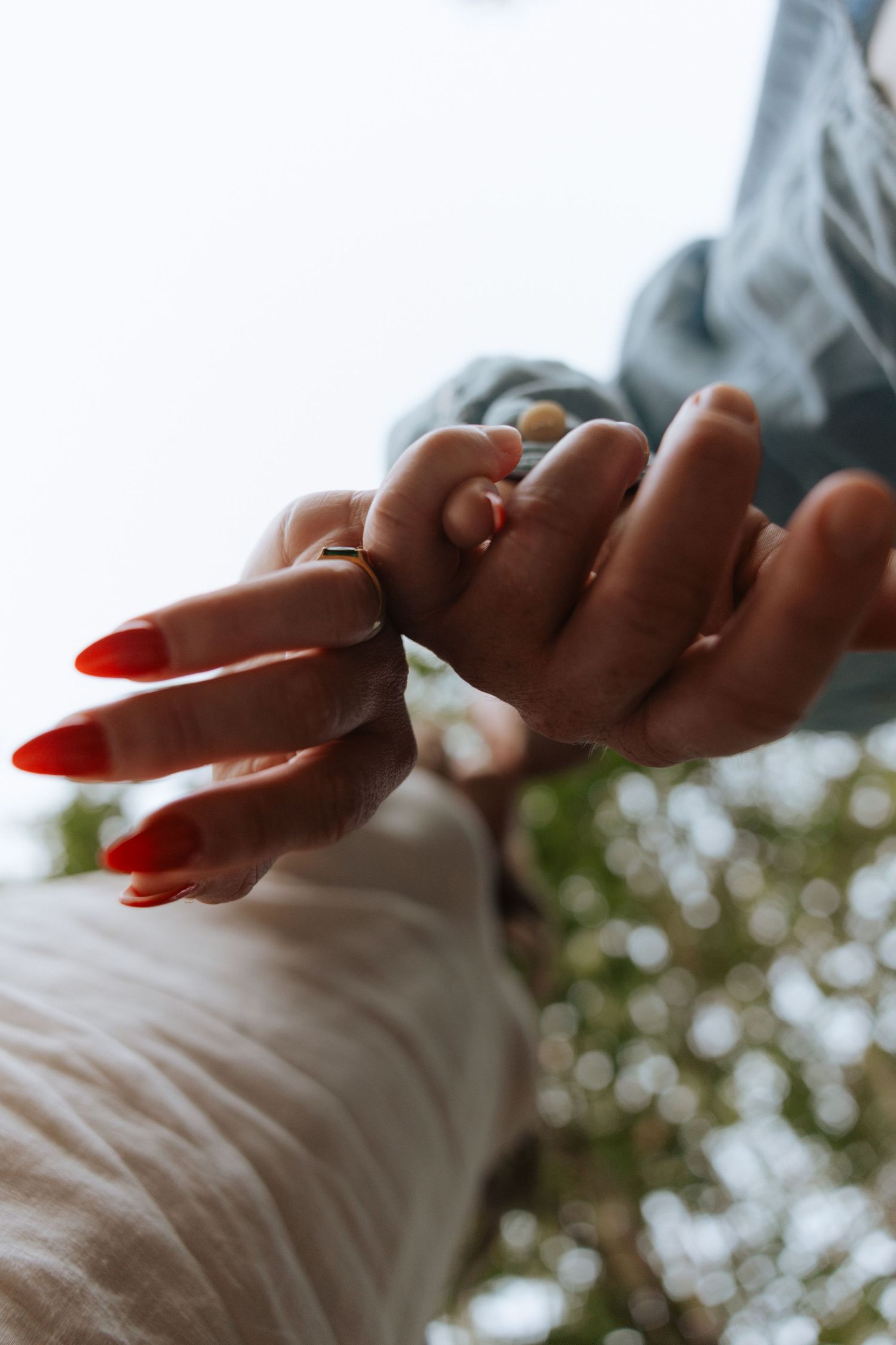 Close-up of an engagement ring on a woman's hand outdoors