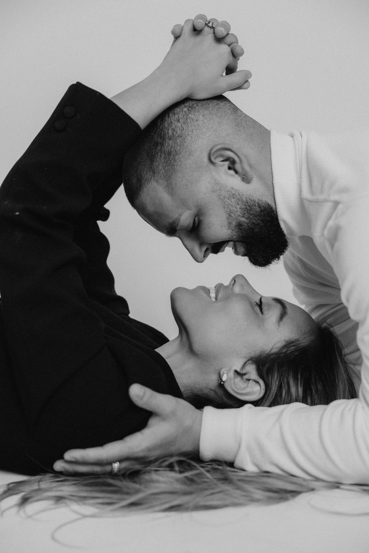 Black and white intimate portrait of a couple laughing and lying together