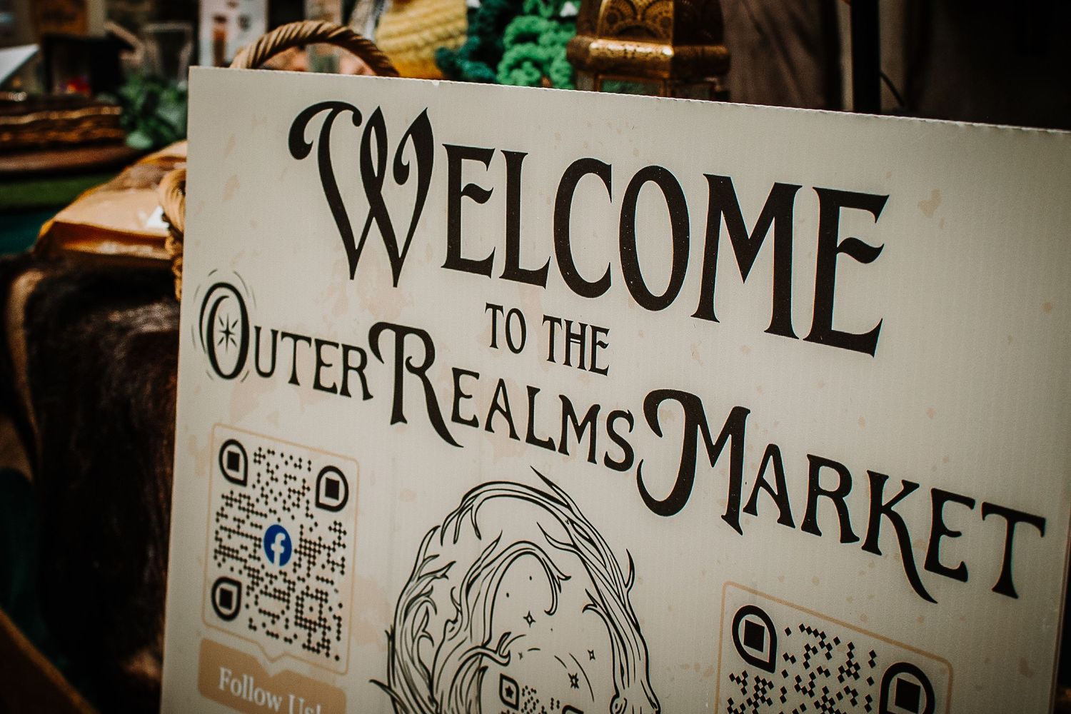 Welcome to the Outer Realms Market decorative sign with QR codes at a fantasy themed event.