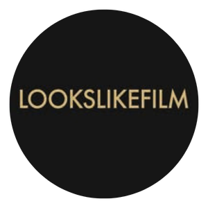 Lookslikefilm gold text photography brand logo on black circular background.