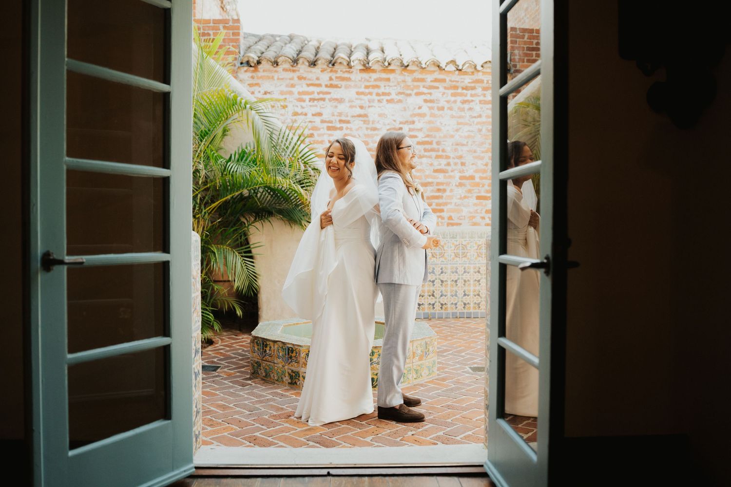 A series of four wedding photos showing a bride in a white dress against a brick wall and courtyard setting.