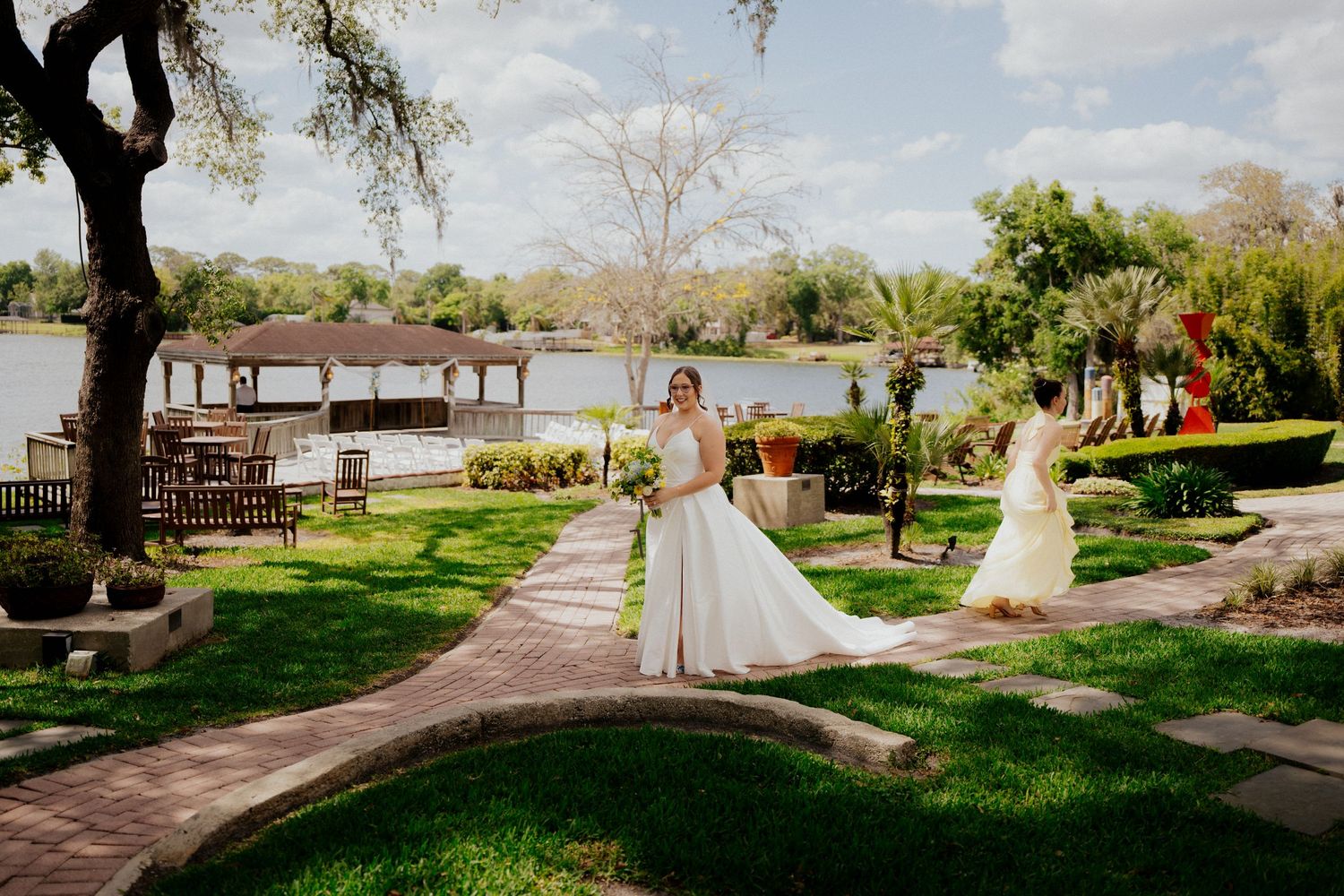Elegant wedding celebration at a waterfront venue with a dock and tropical landscaping on a sunny day at enzos on the lake