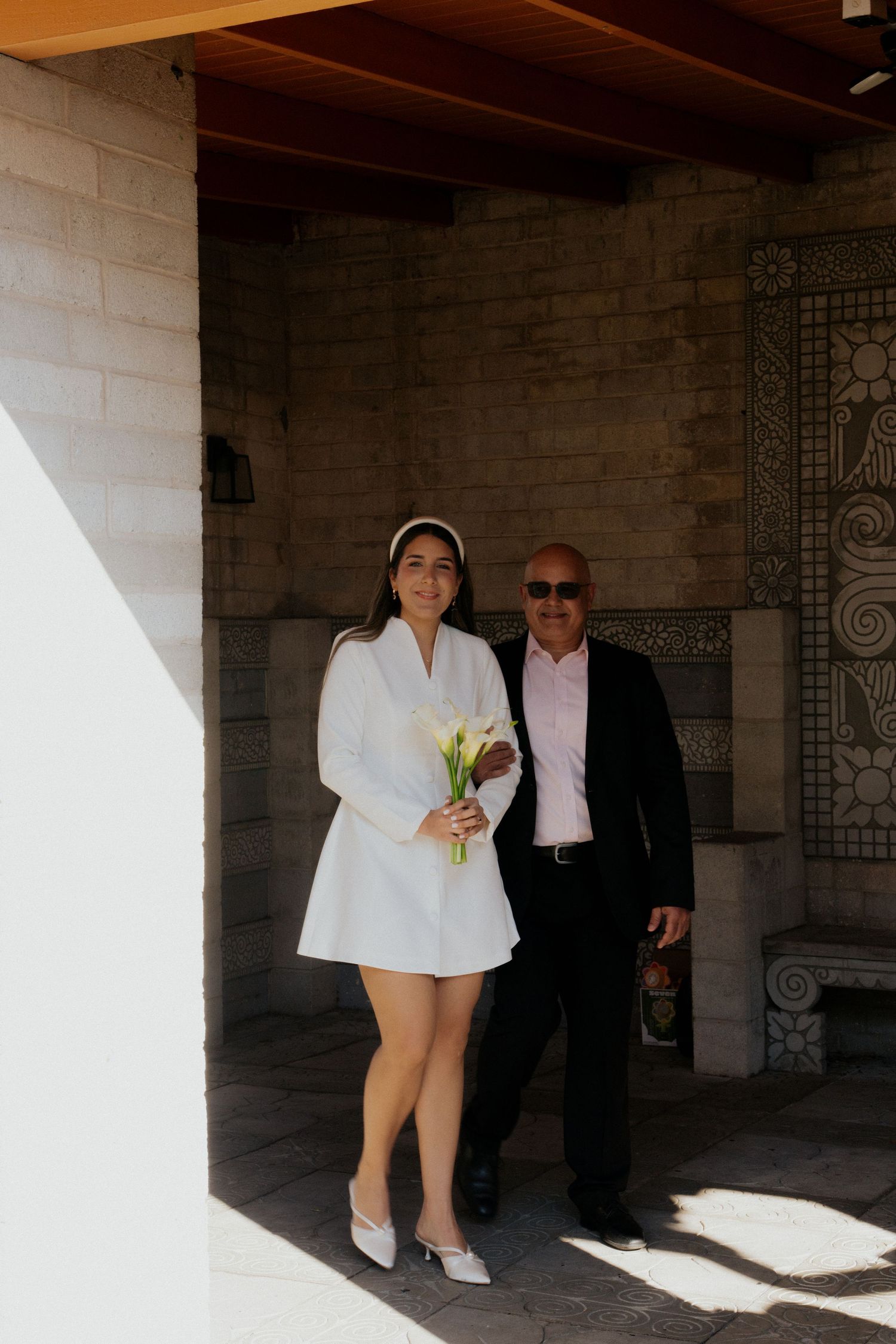 A series of photos showing two people walking through a covered walkway with stone columns and decorative walls.