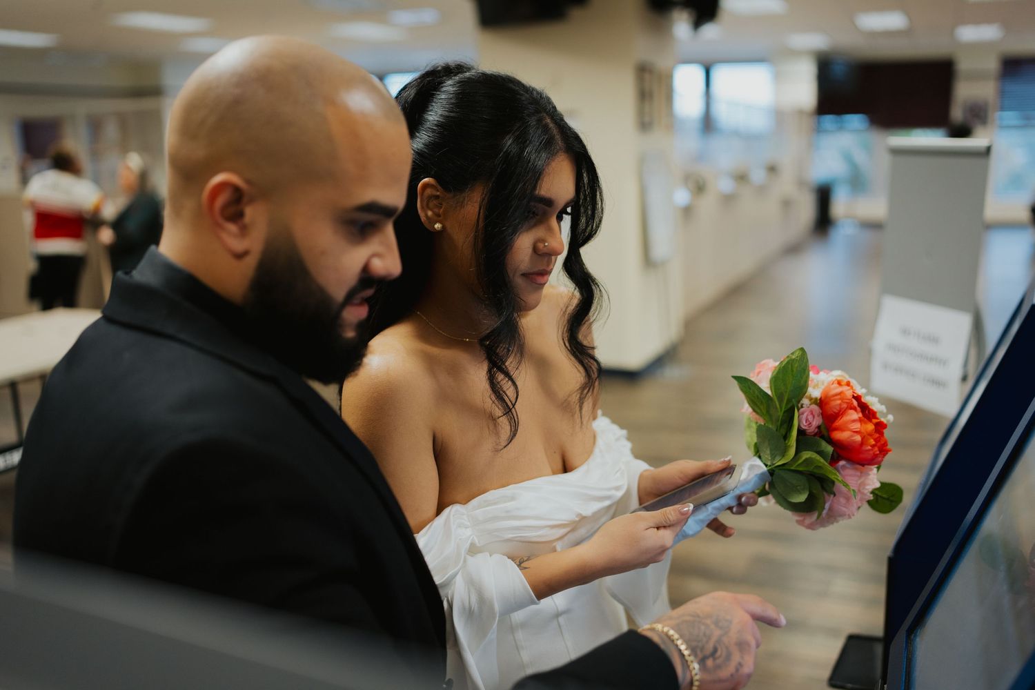 A couple looking at documents together while holding a red rose in an office setting.