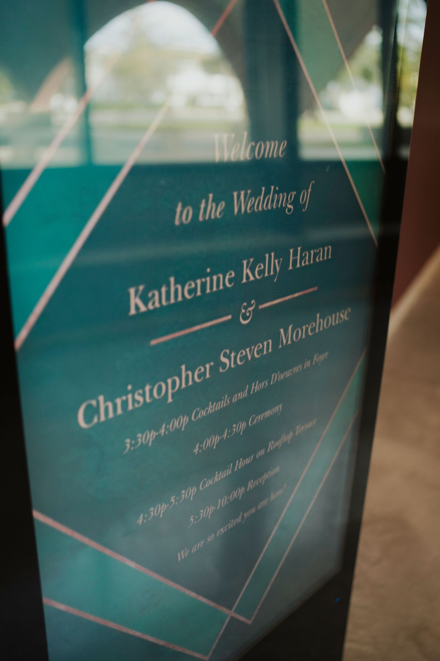 Teal wedding welcome sign with elegant geometric design and script text details.