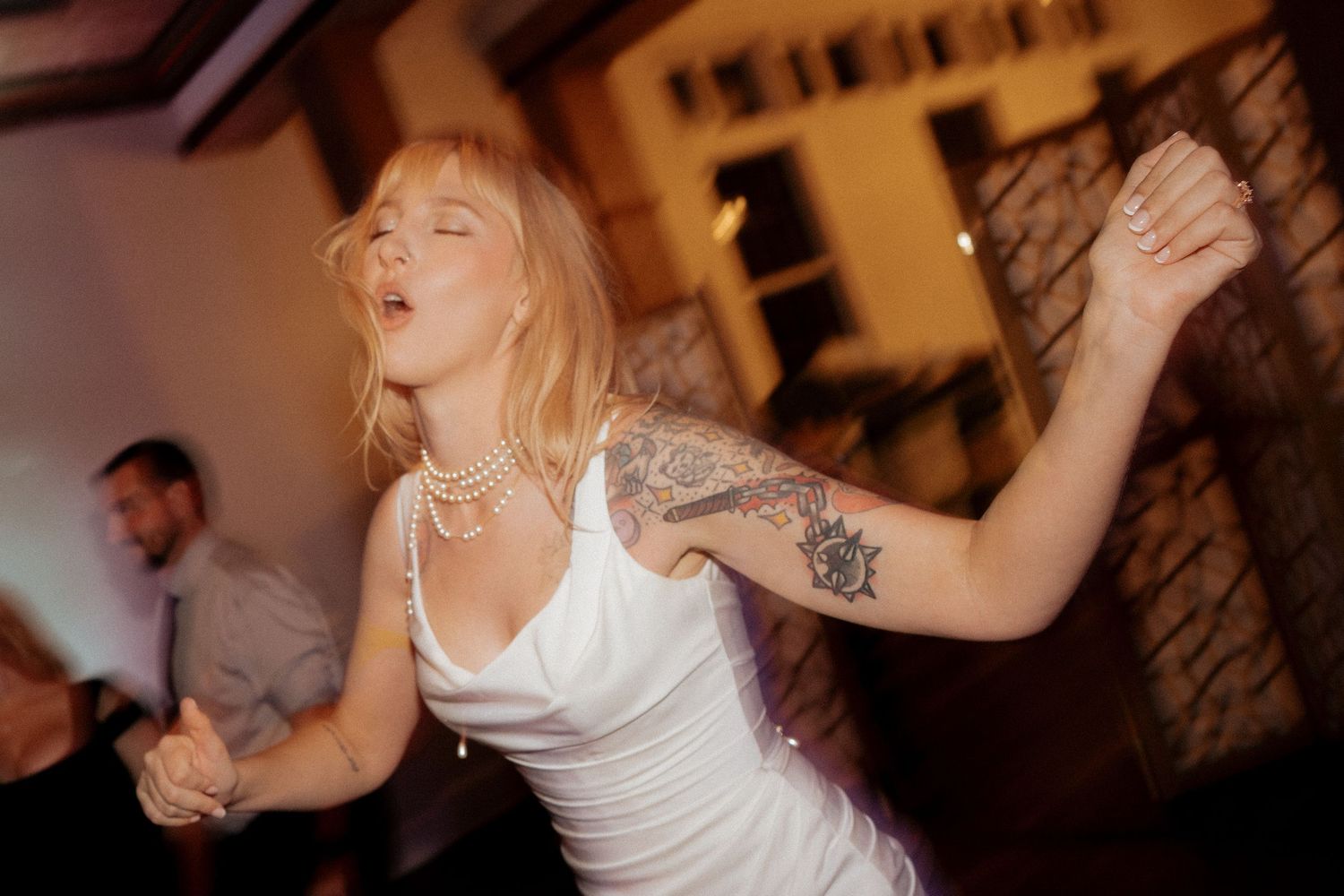 A group of people dancing and celebrating at a lively wedding reception party.
