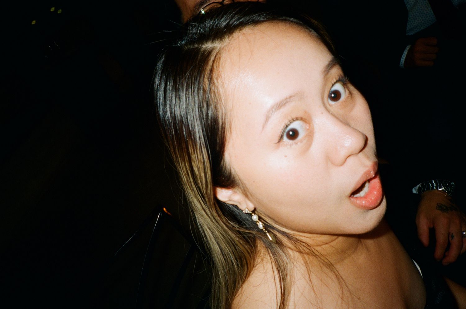 Young Asian woman making a funny surprised face at a party event.