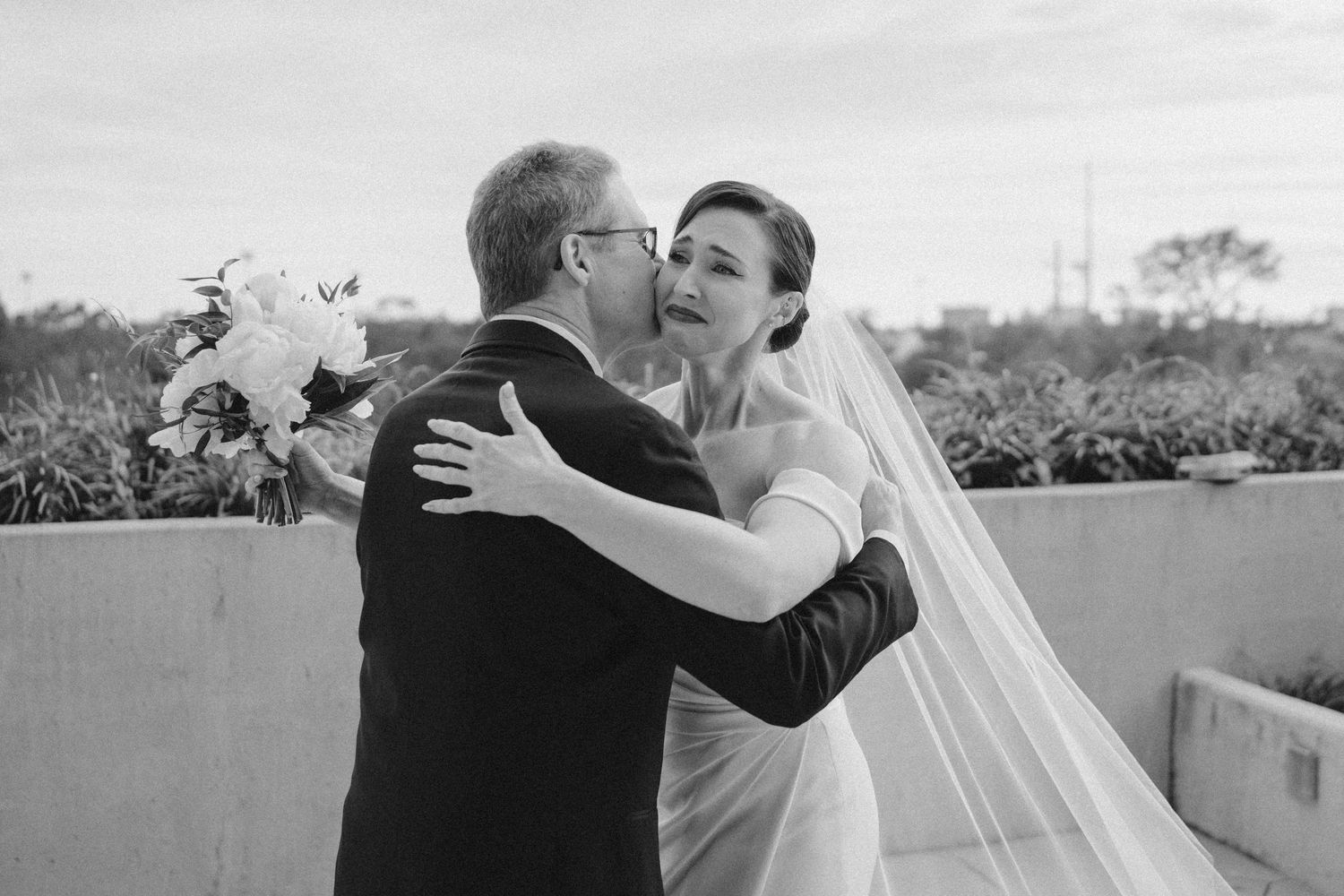 Black and white wedding photos showing romantic moments between newlyweds outdoors.