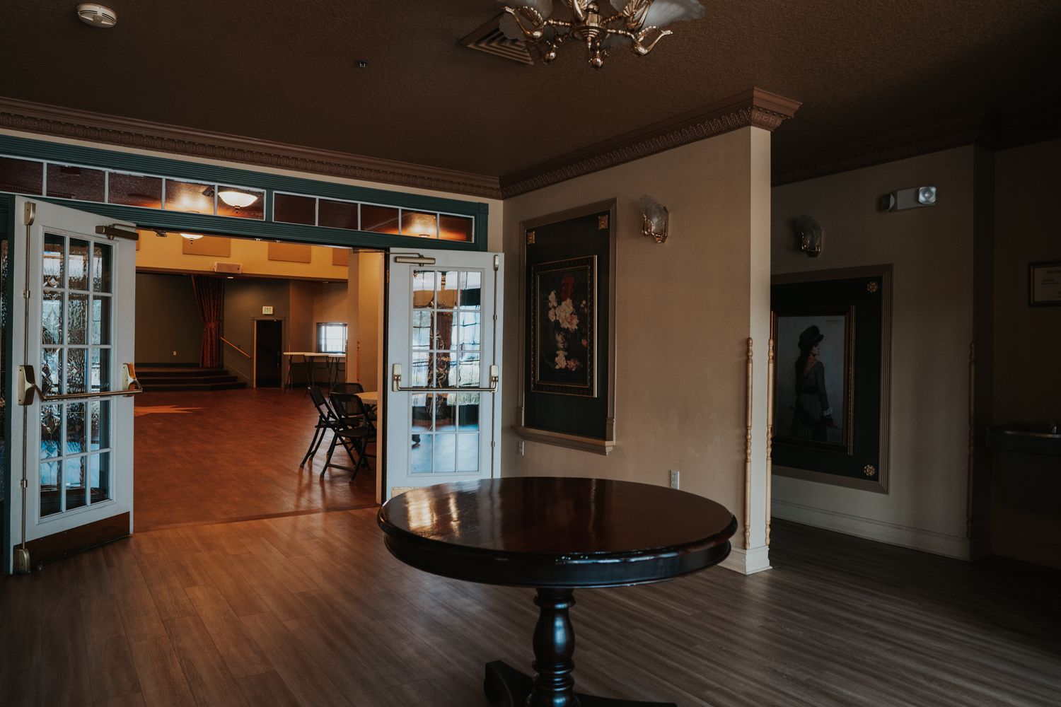 Spacious room with wooden floors, round table, and glass doors.