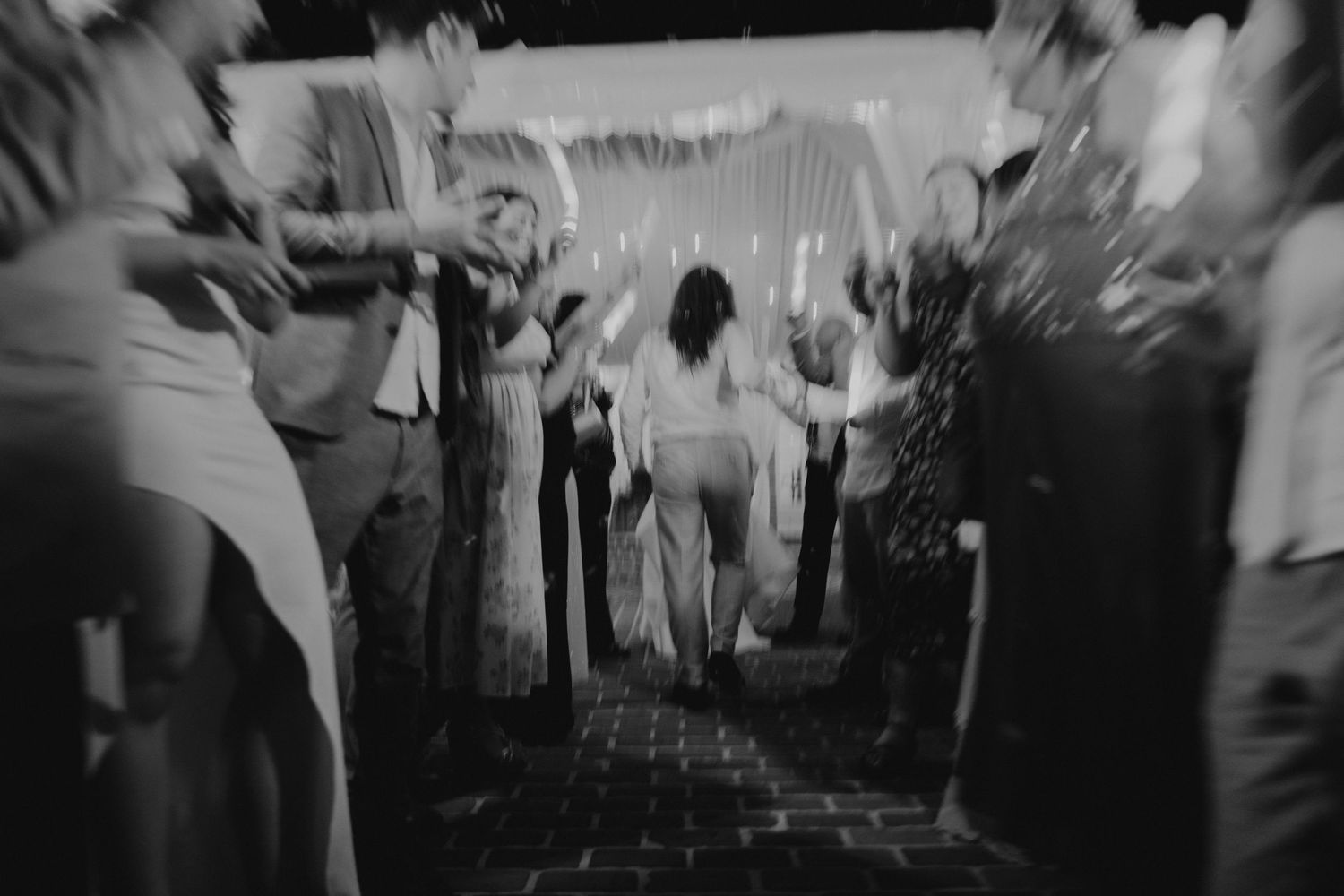 Black and white motion-blurred photo of guests dancing at a wedding reception , send off at Casa Feliz
