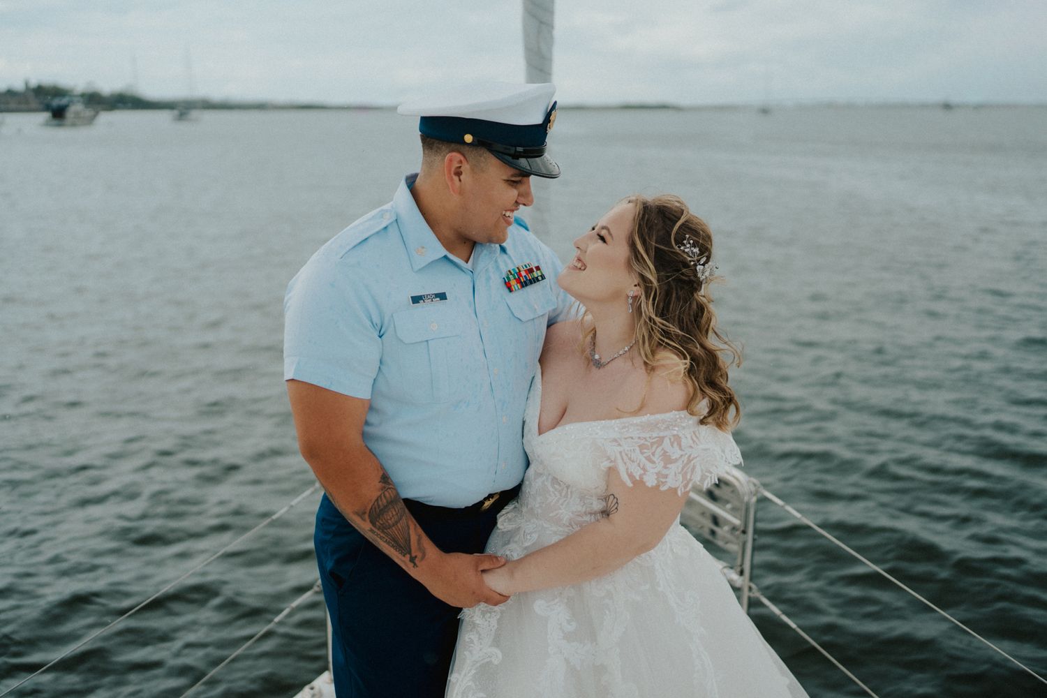 A romantic moment captured between a couple on a boat with the ocean as their backdrop.