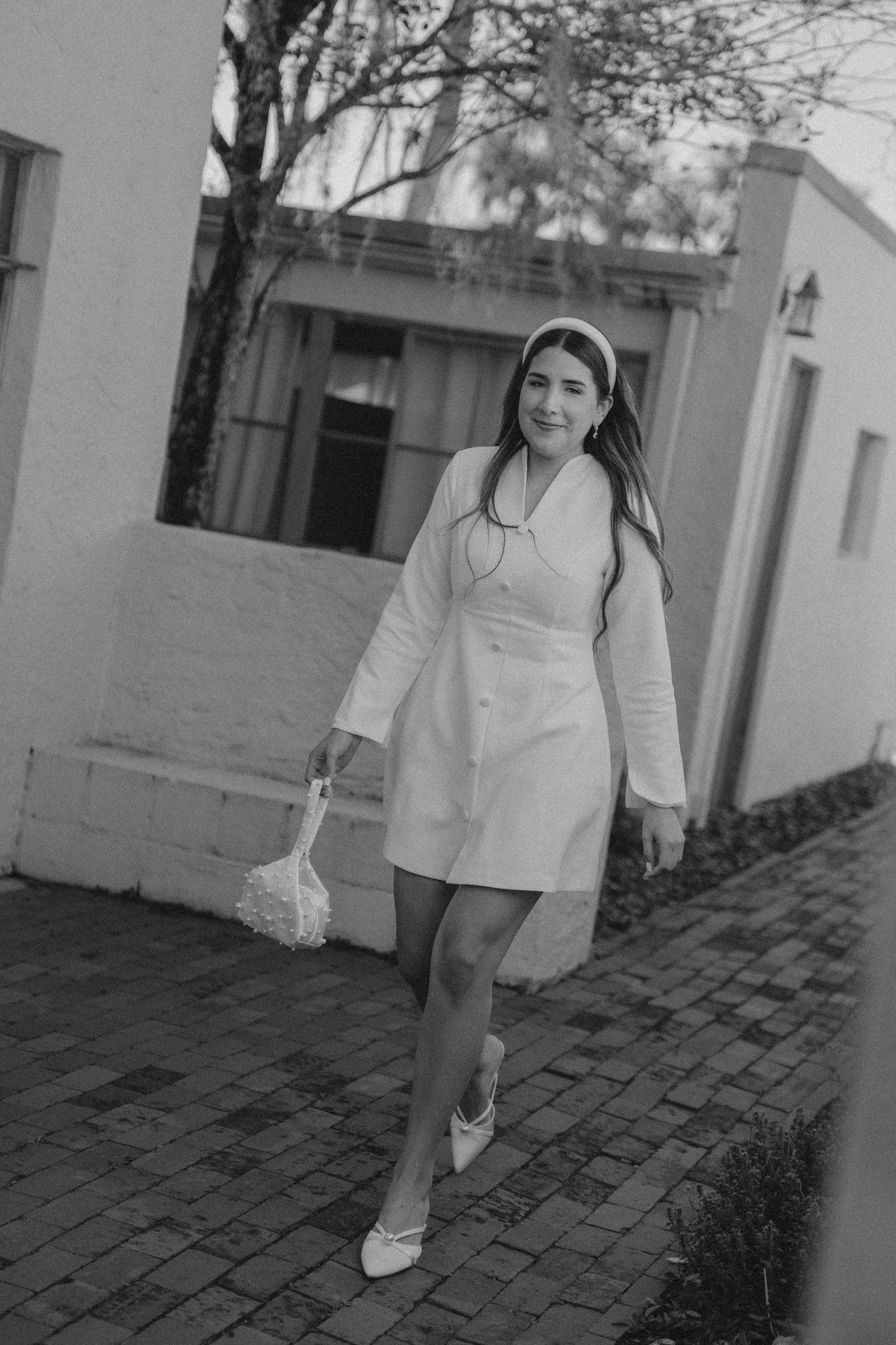 Black and white photos of a person walking on brick pavement in white clothing.