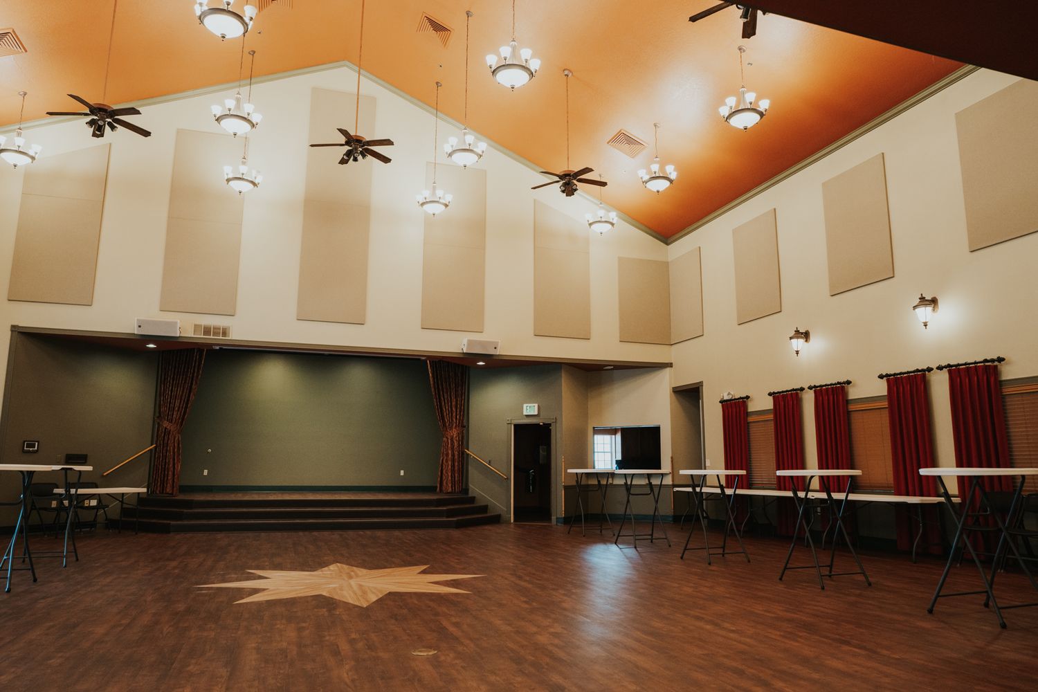 Large multipurpose hall with high ceilings, track lighting, and decorative wall panels.