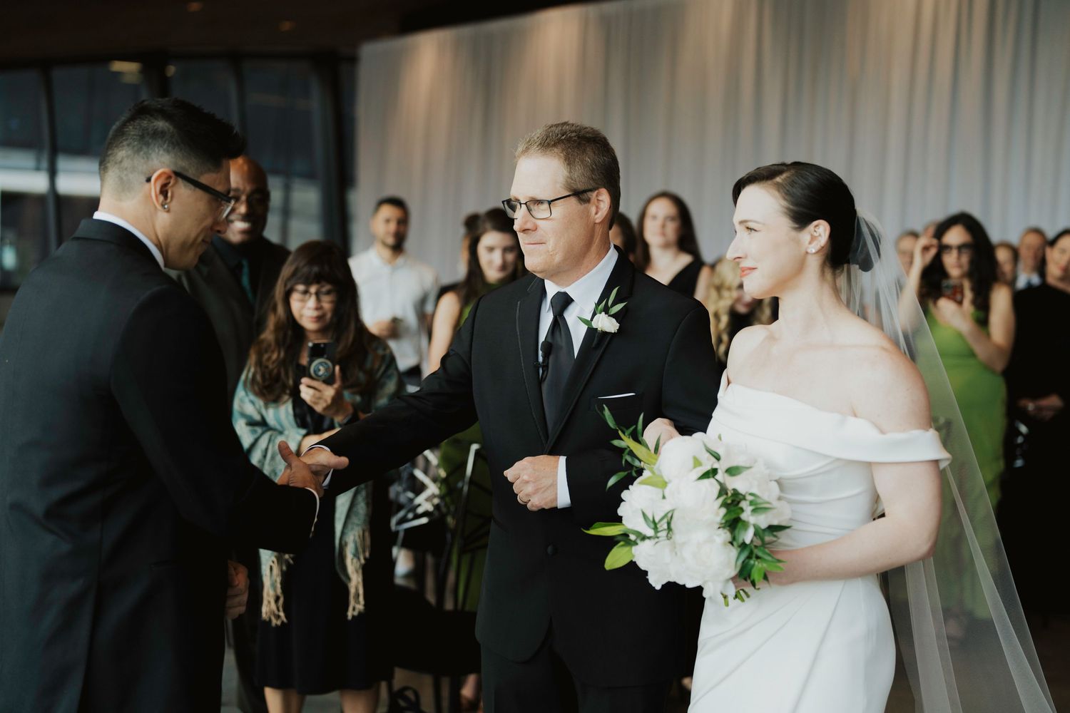 Wedding guests mingle and socialize during a reception in an elegant indoor venue.