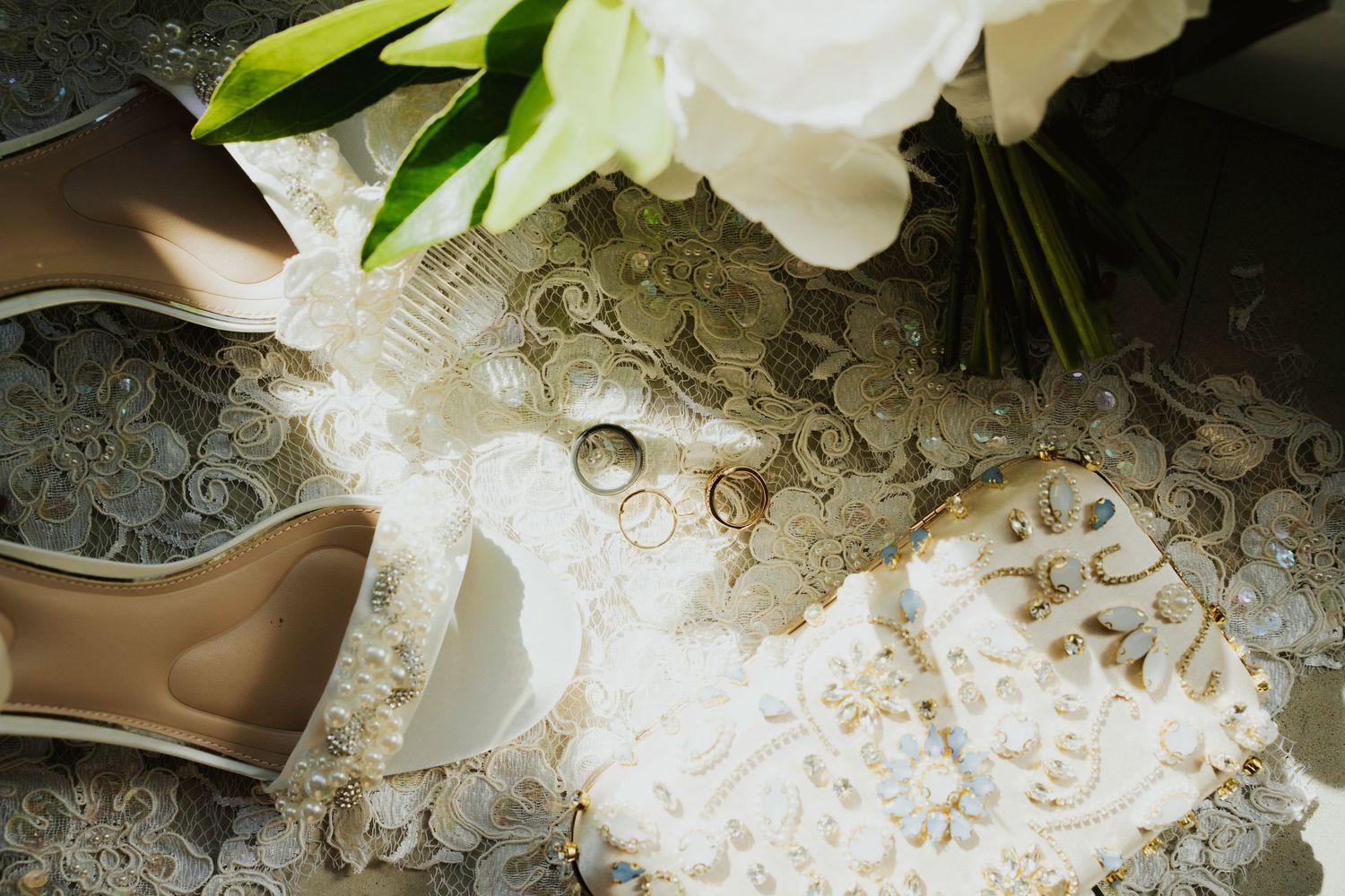 A close-up view of delicate white lace fabric with intricate floral patterns and embroidered details.