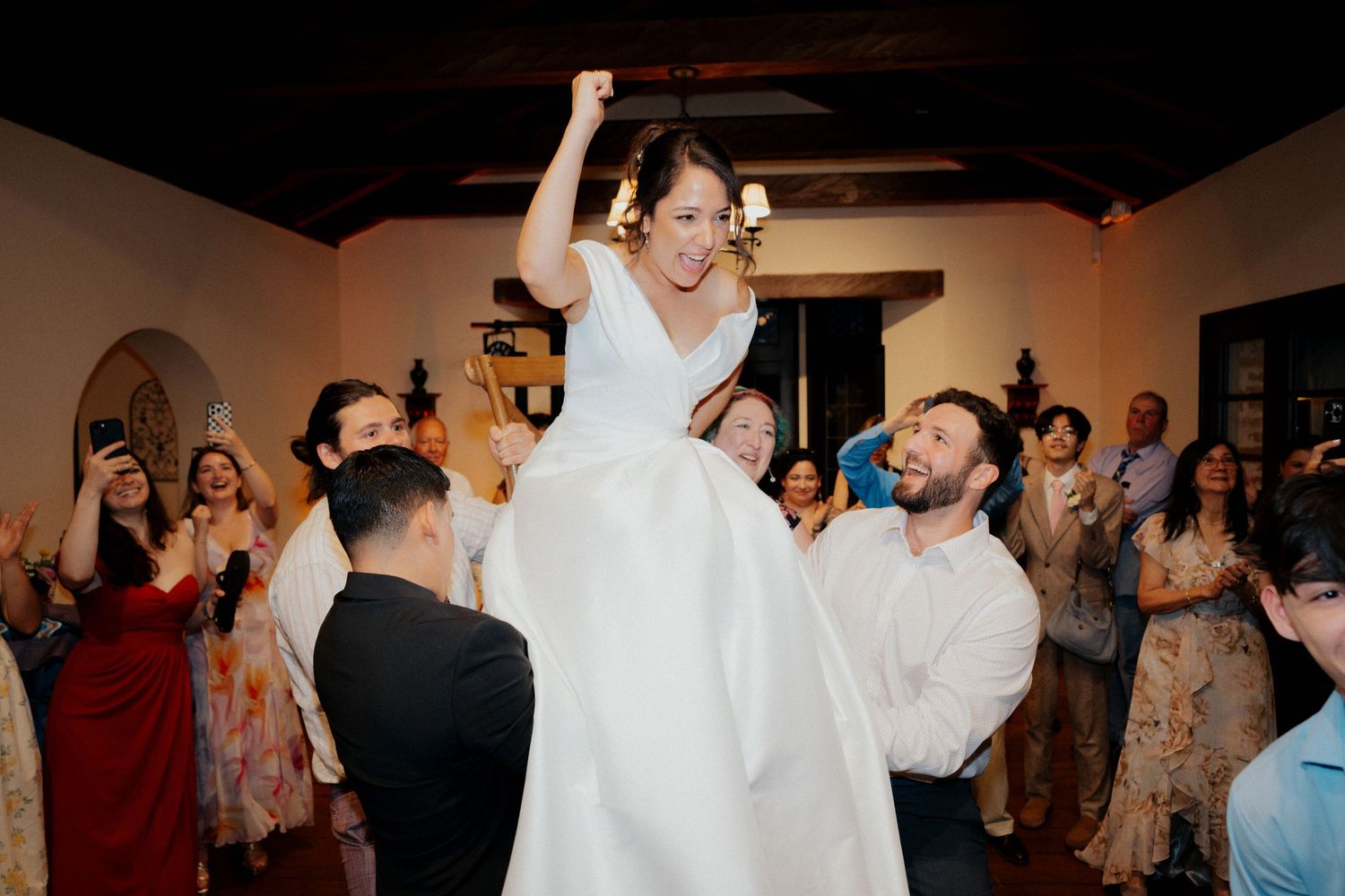 Celebratory moment during a wedding reception with dancing and cheering.