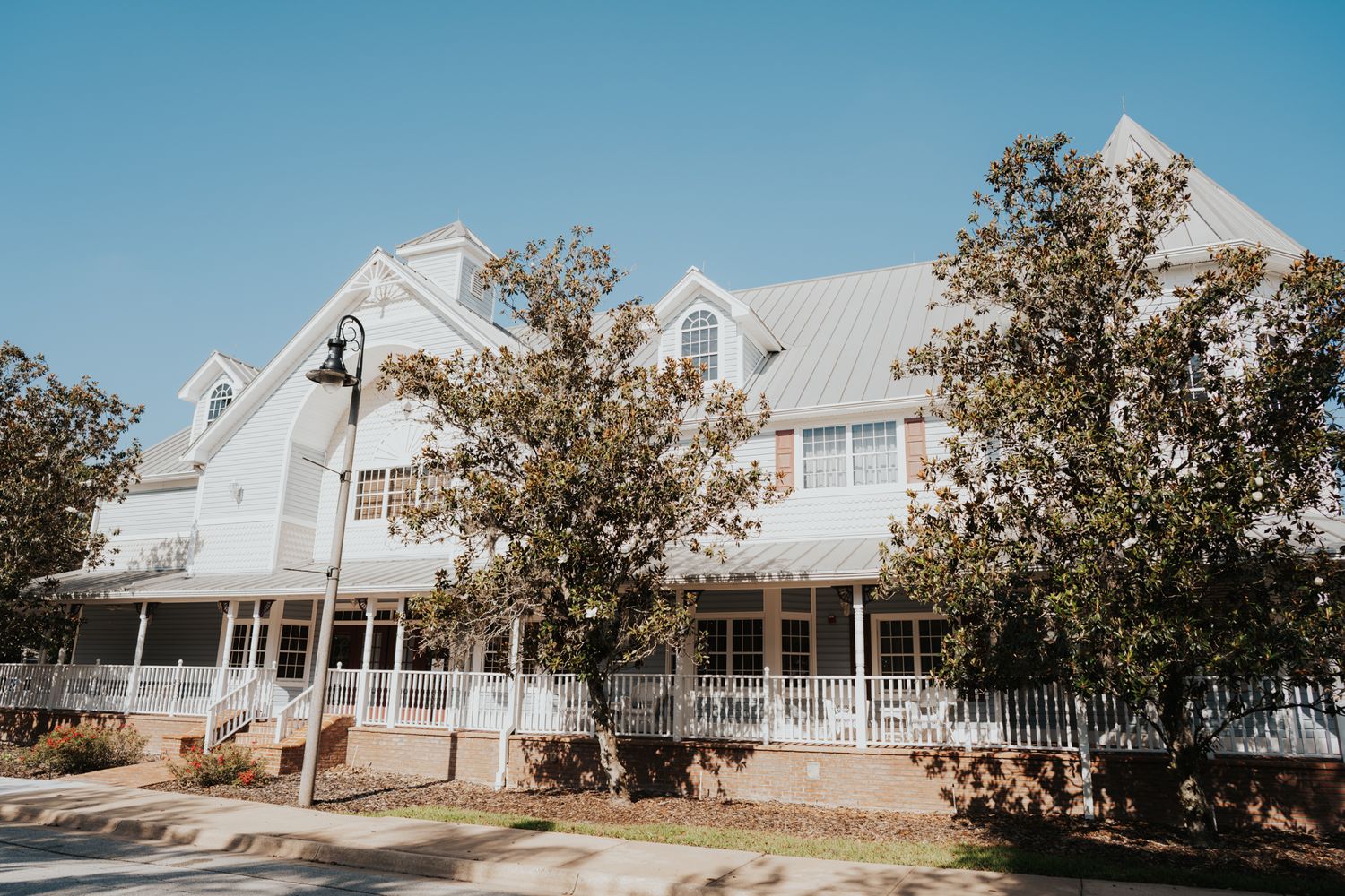 White coastal-style building with multiple gables and covered porches.