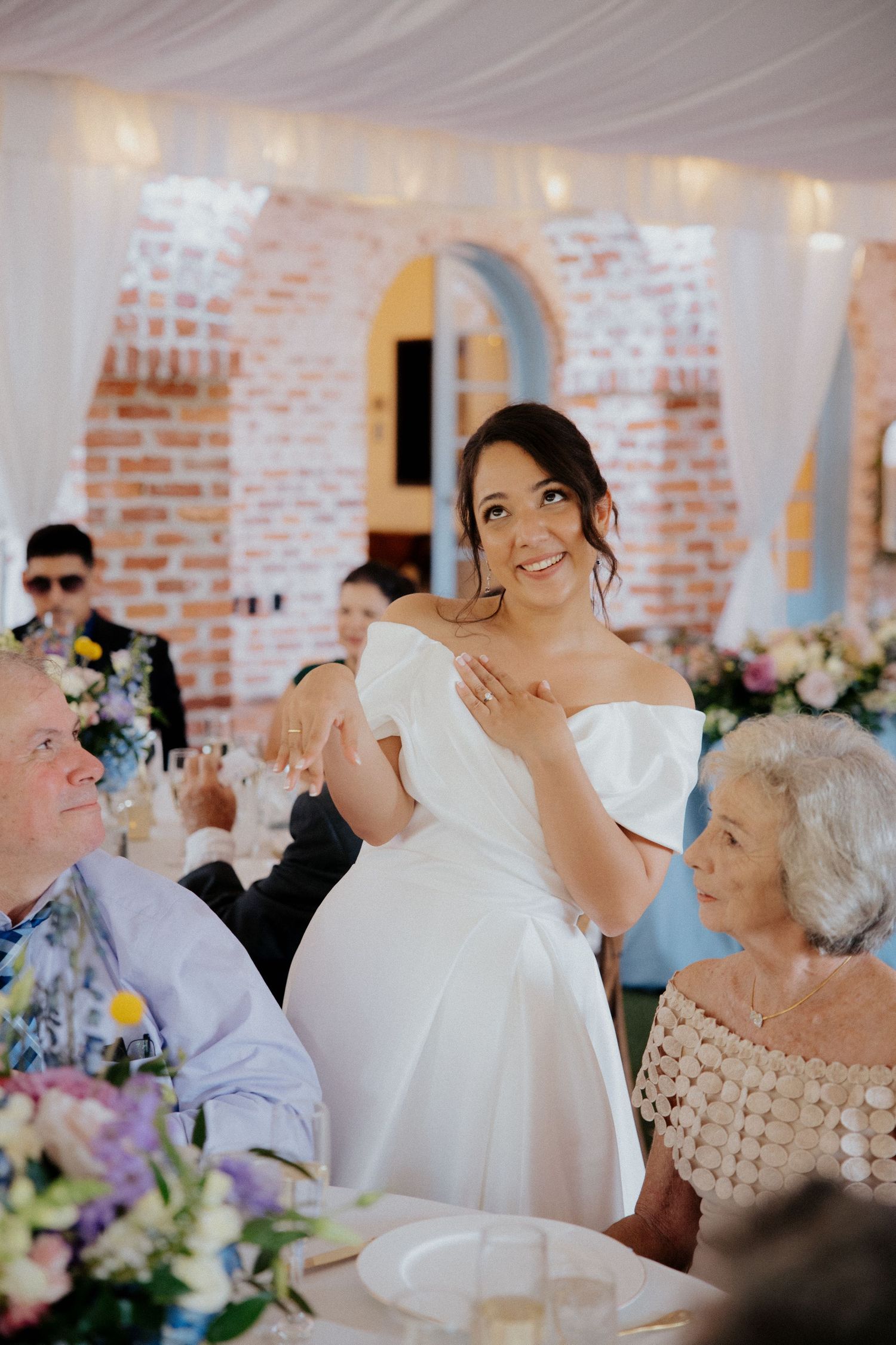 Wedding reception scene in a rustic brick venue with white decor and floral arrangements at historic casa feliz wedding venue