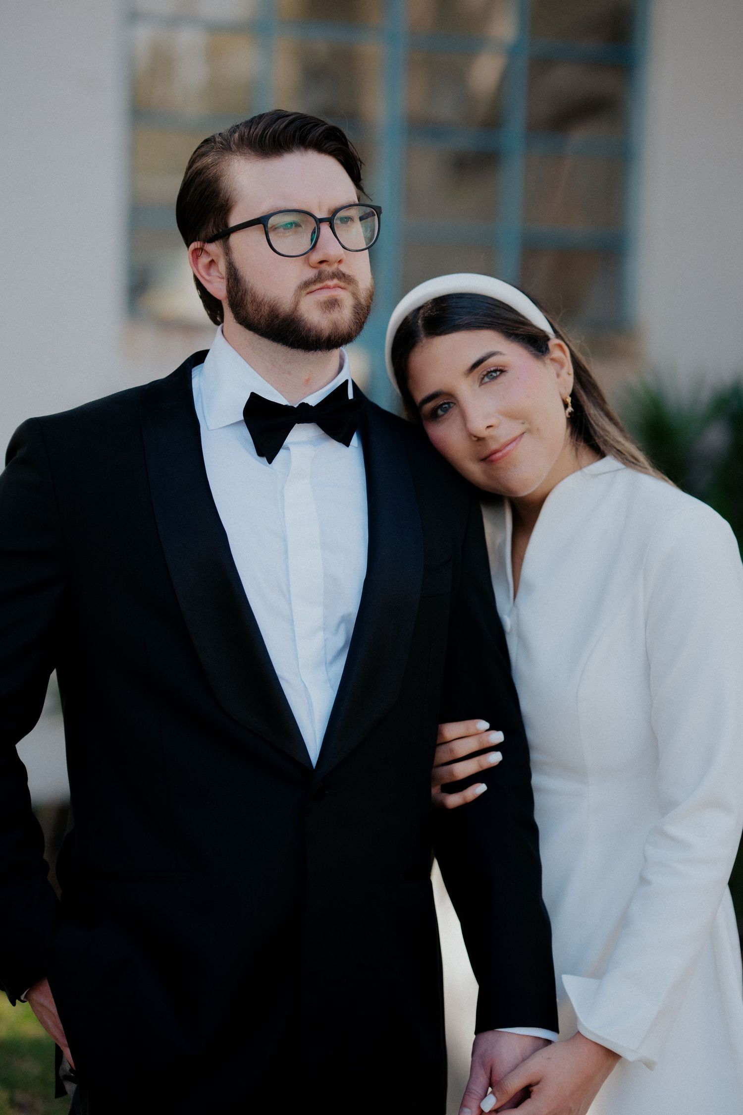 A romantic wedding couple in formal attire poses together in an intimate series of portraits.
