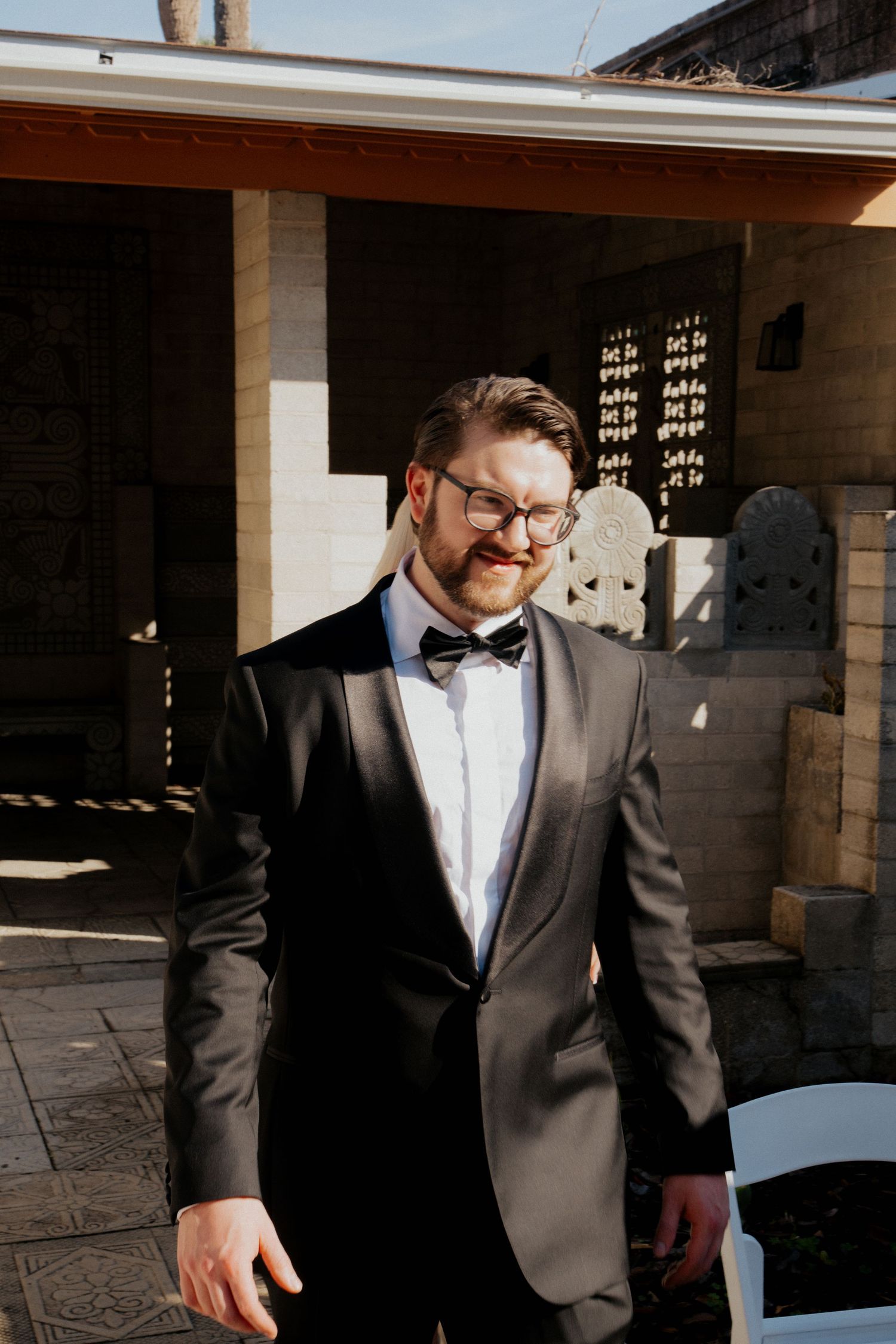 A sequence of candid shots showing someone in a dark suit walking through a sunlit architectural space.