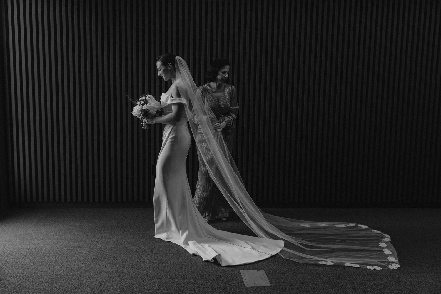 A series of black and white wedding photos showing a flowing bridal veil and dress in dramatic lighting.