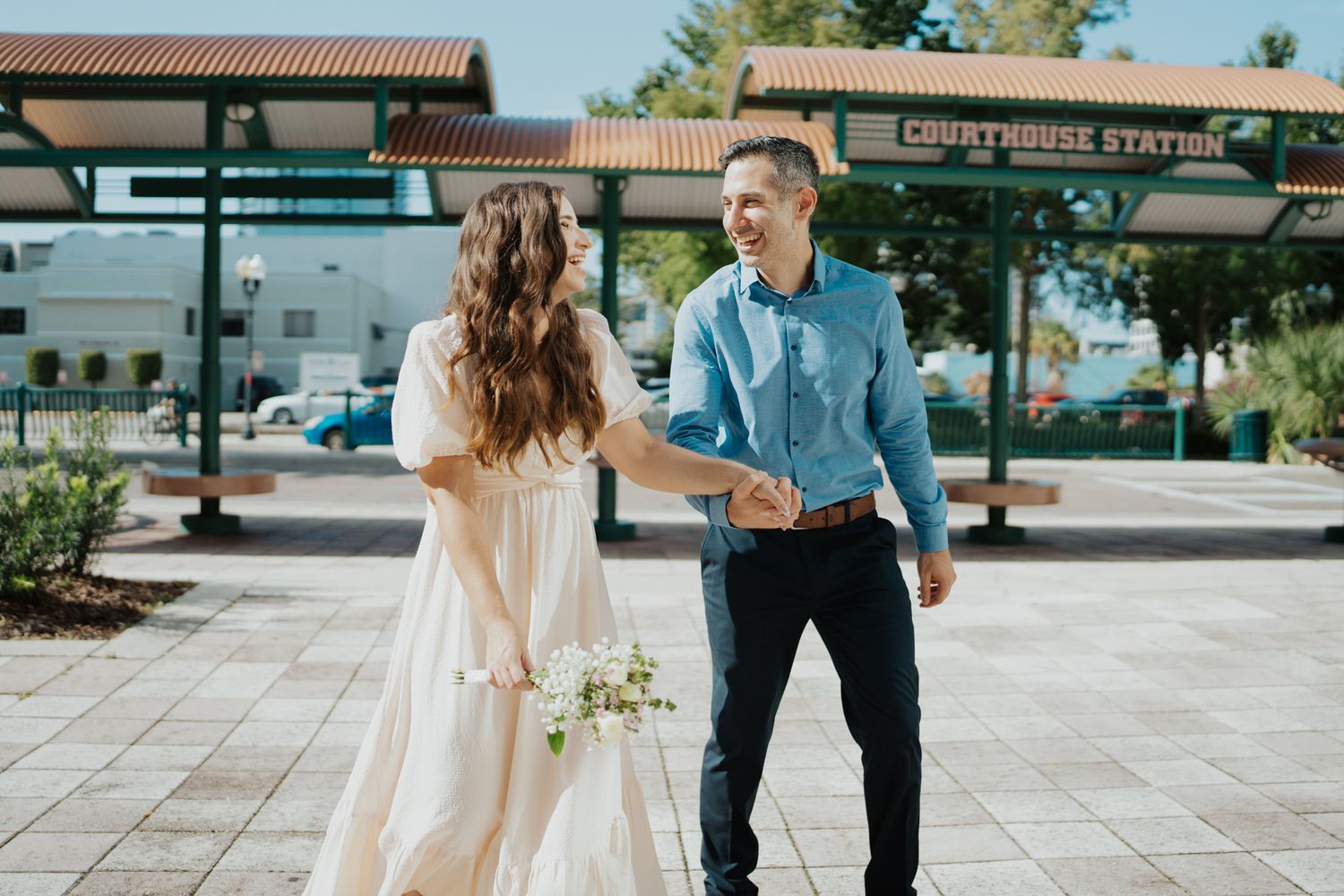 A joyful couple shares a candid moment in front of a coffee station outdoors.