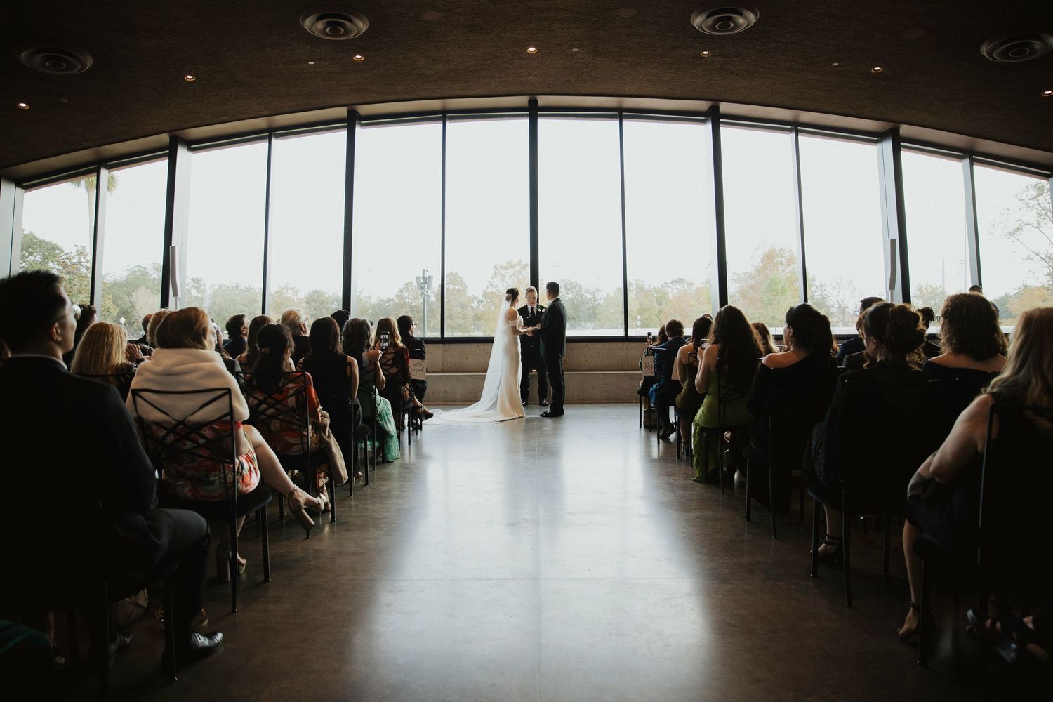 Modern wedding venue with floor-to-ceiling windows overlooking city views at dusk.
