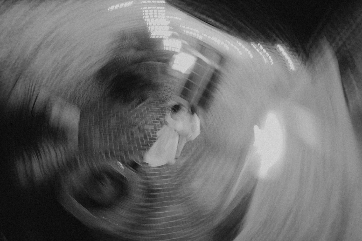 Black and white spiral pattern creates an abstract hypnotic effect against a dark background.