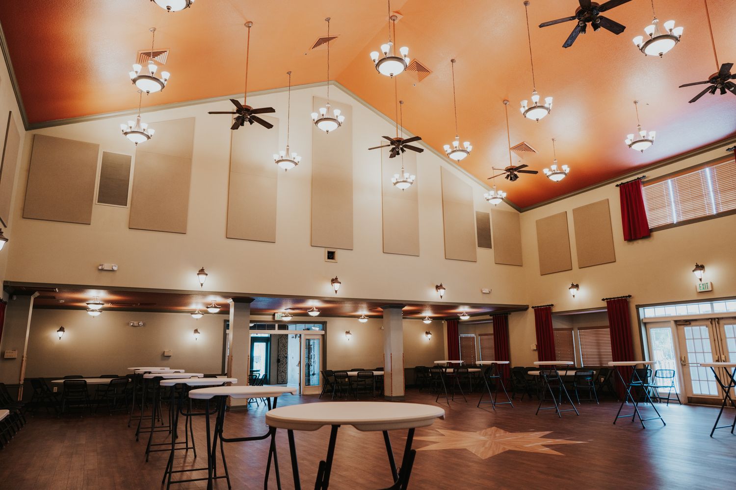 Large event hall with high ceilings, ceiling fans, and pendant lighting.