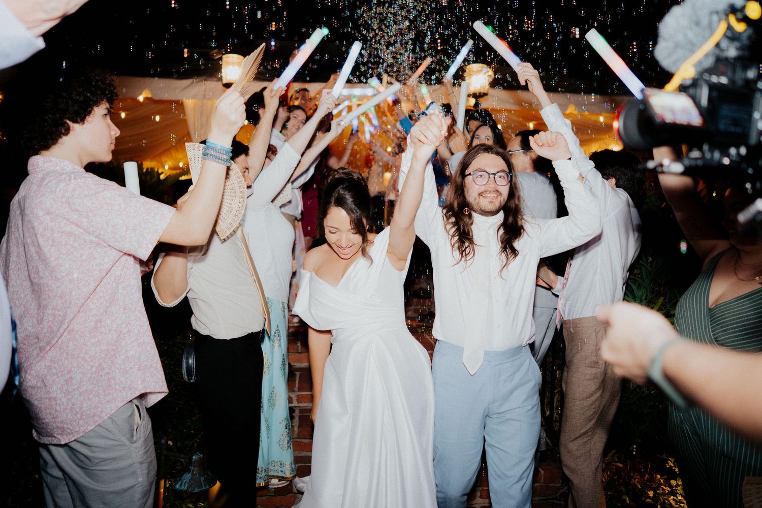 Wedding celebration with guests dancing and sparklers creating a festive atmosphere.