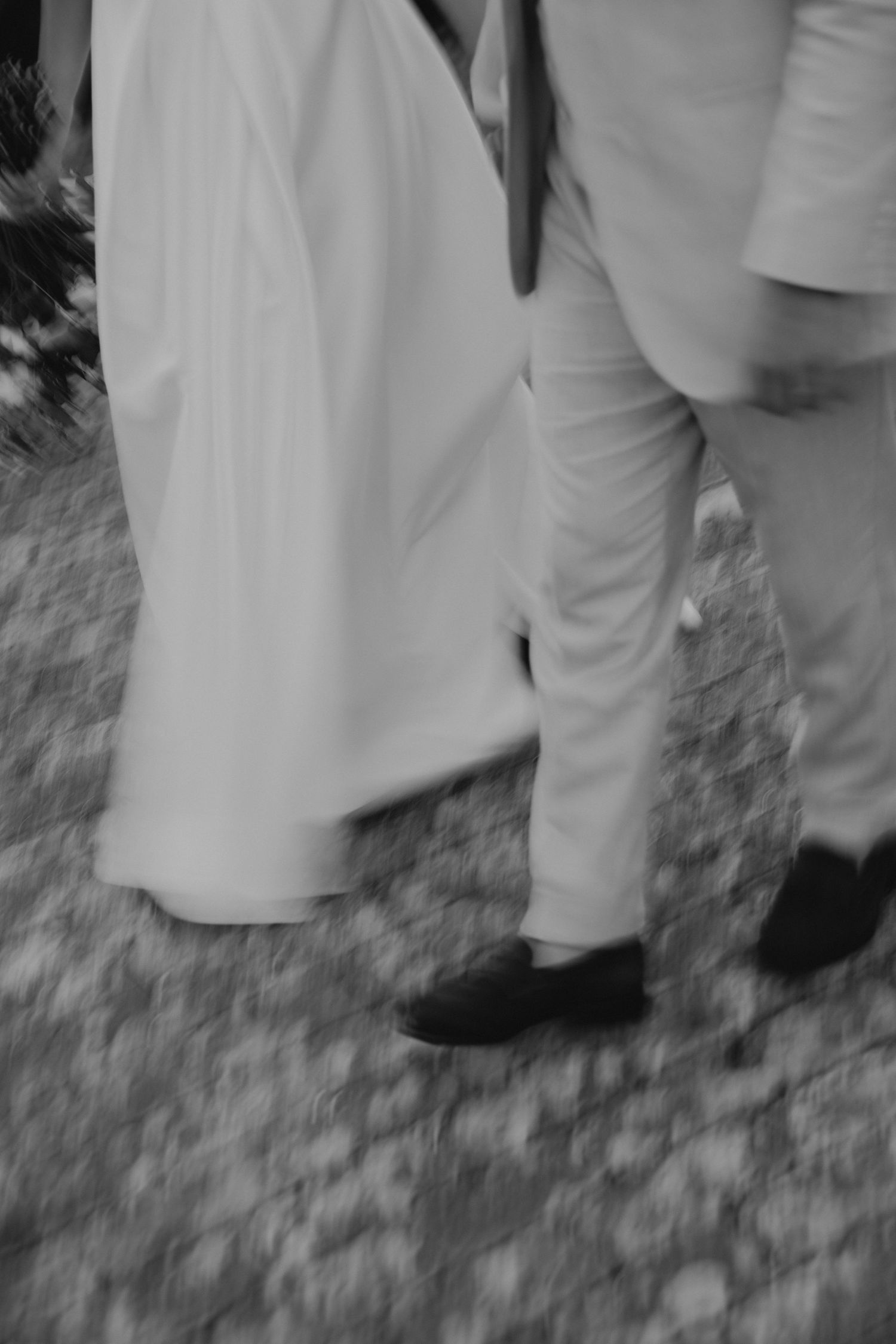 Black and white detail shots of formal wedding attire and movement.