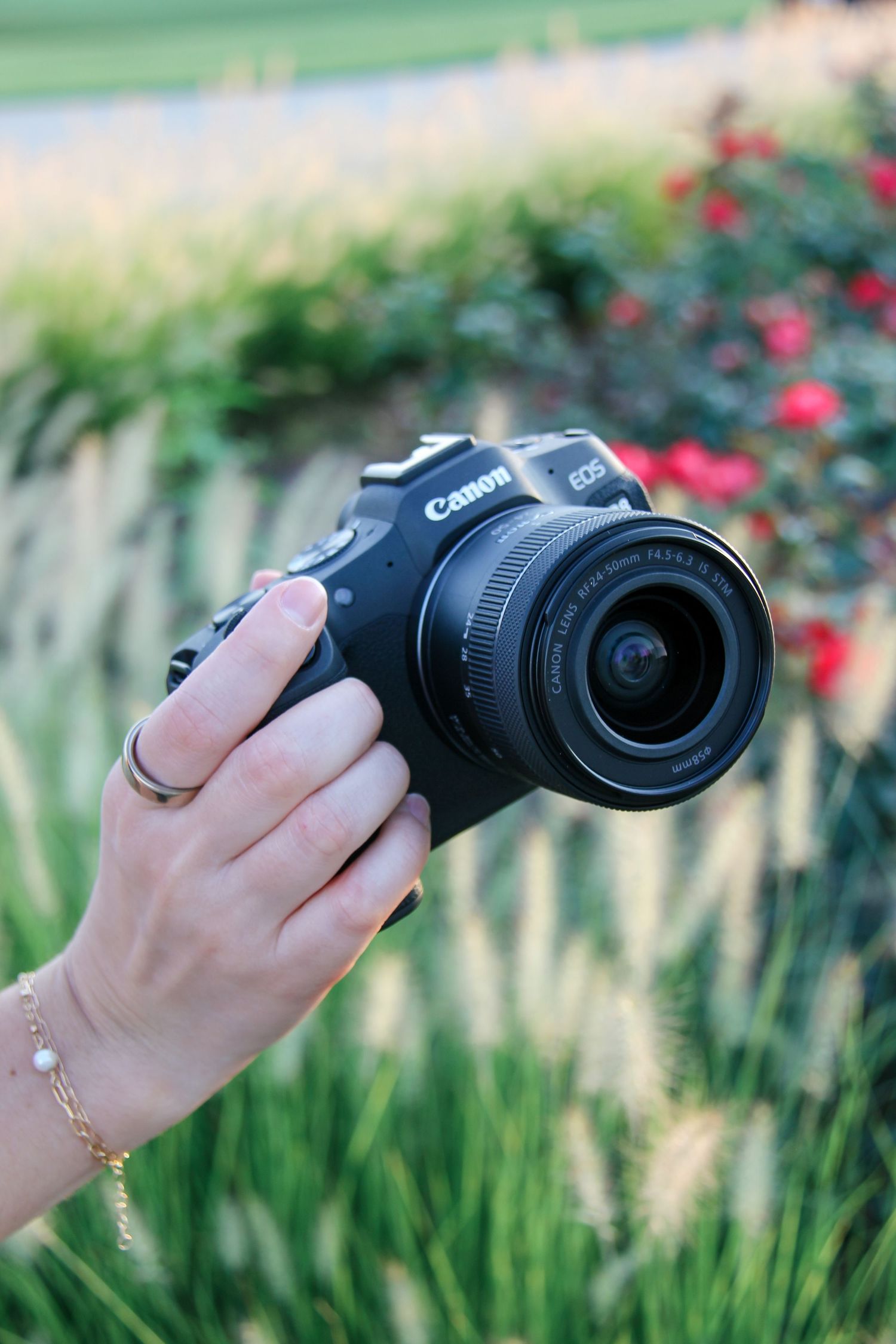 Photographer holding a camera in a flower garden.