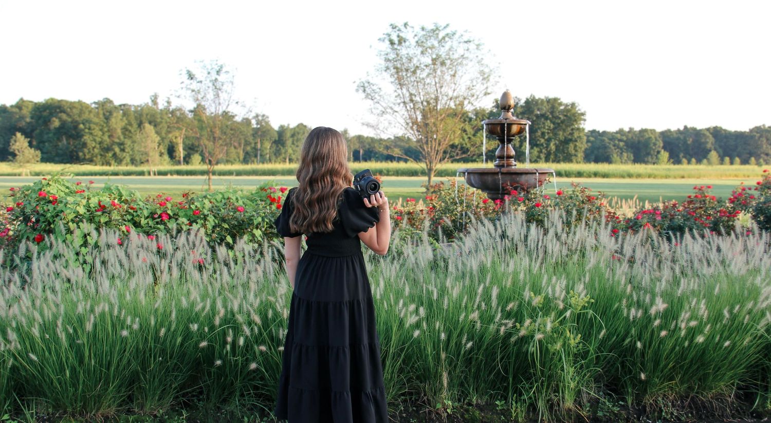 Central Illinois photographer standing in a colorful flower garden.