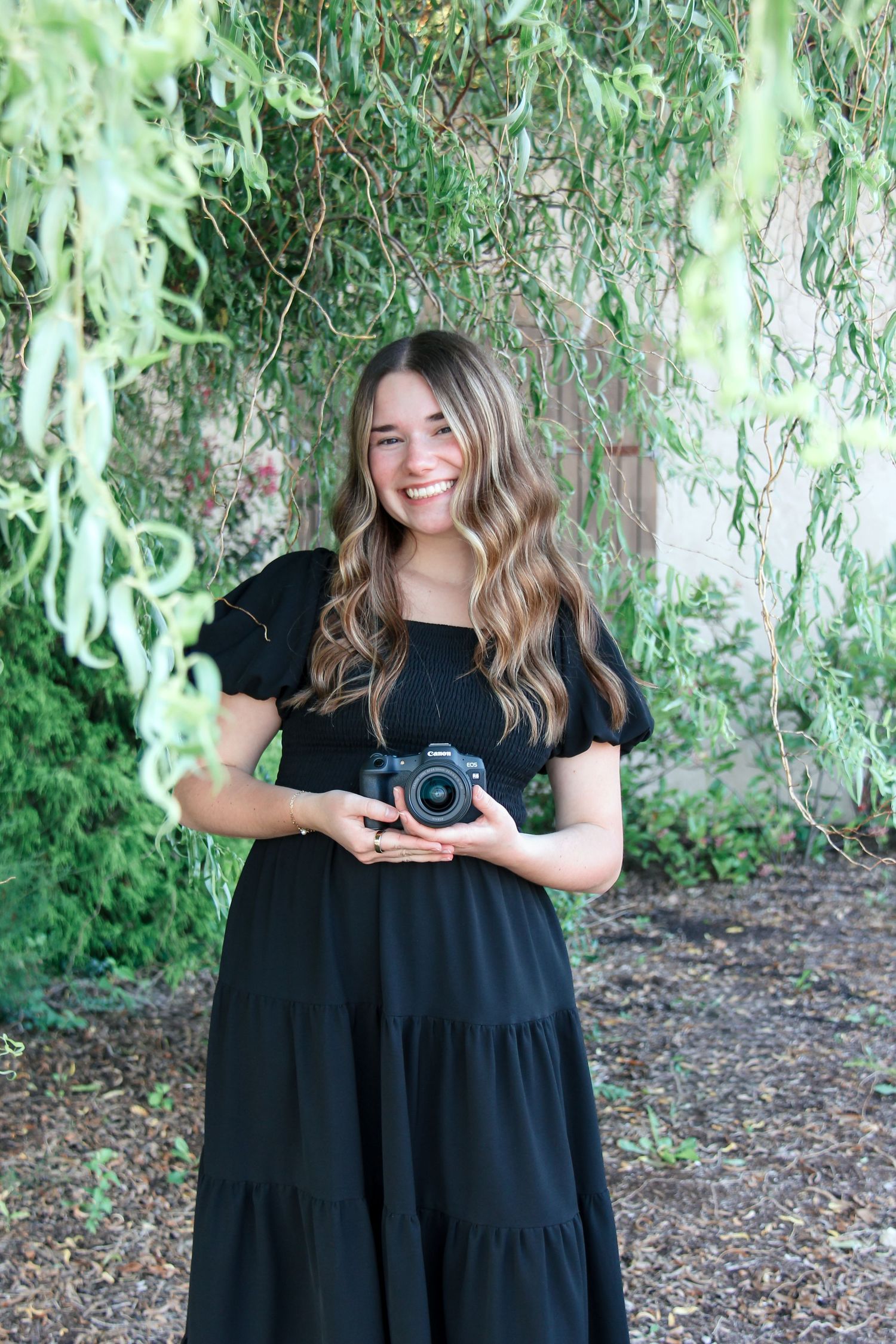 Portrait of a photographer surrounded by greenery and flowers.