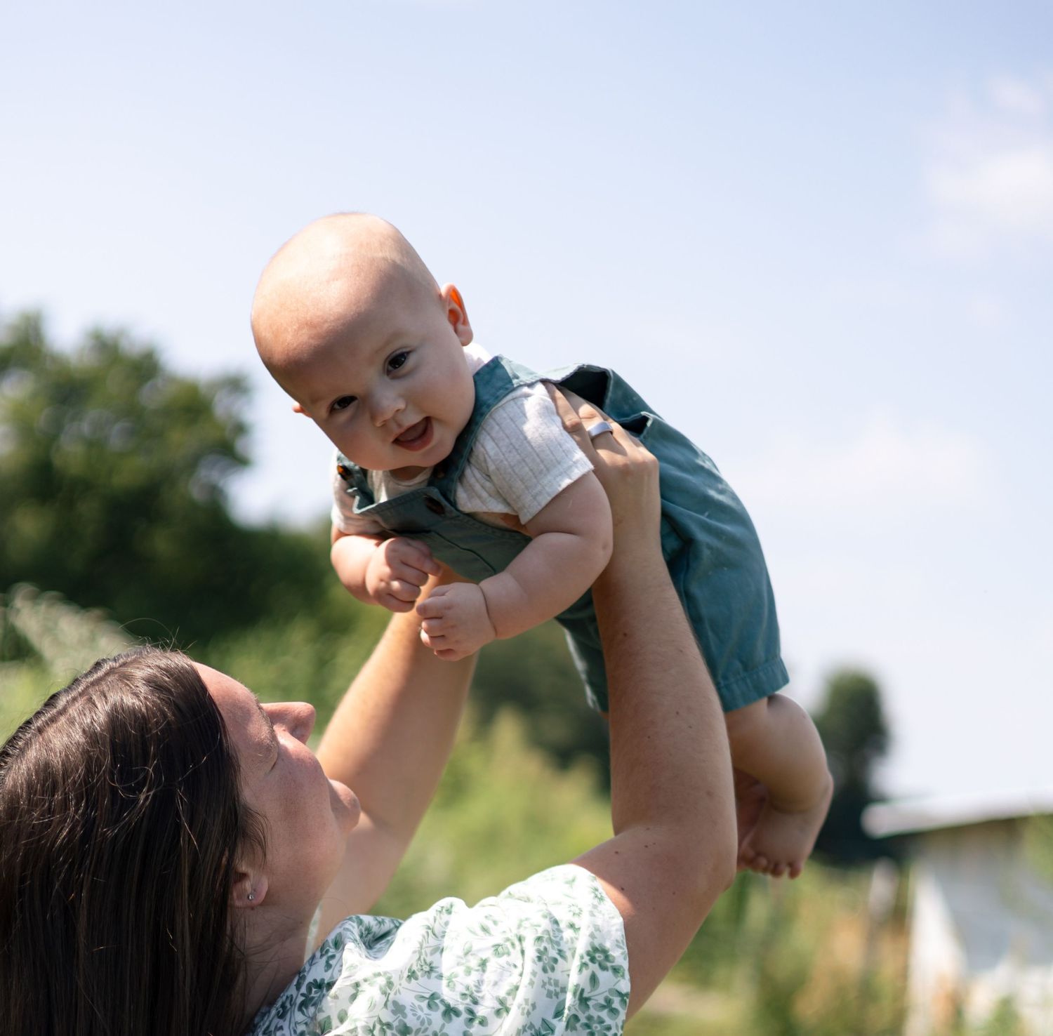 Mother smiling at her young son during an outdoor family photography session.