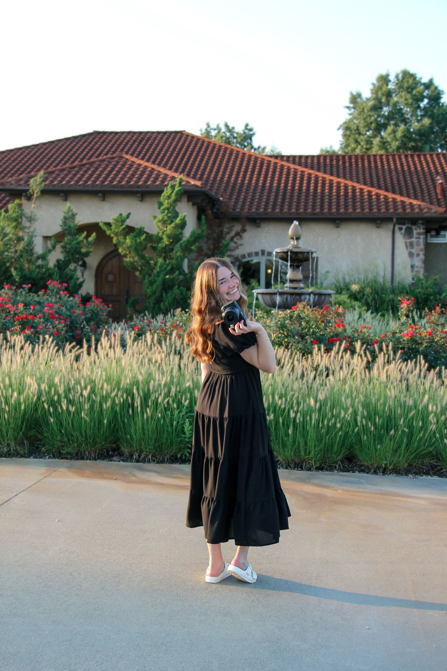 Portrait of a photographer standing outdoors in a flower garden.