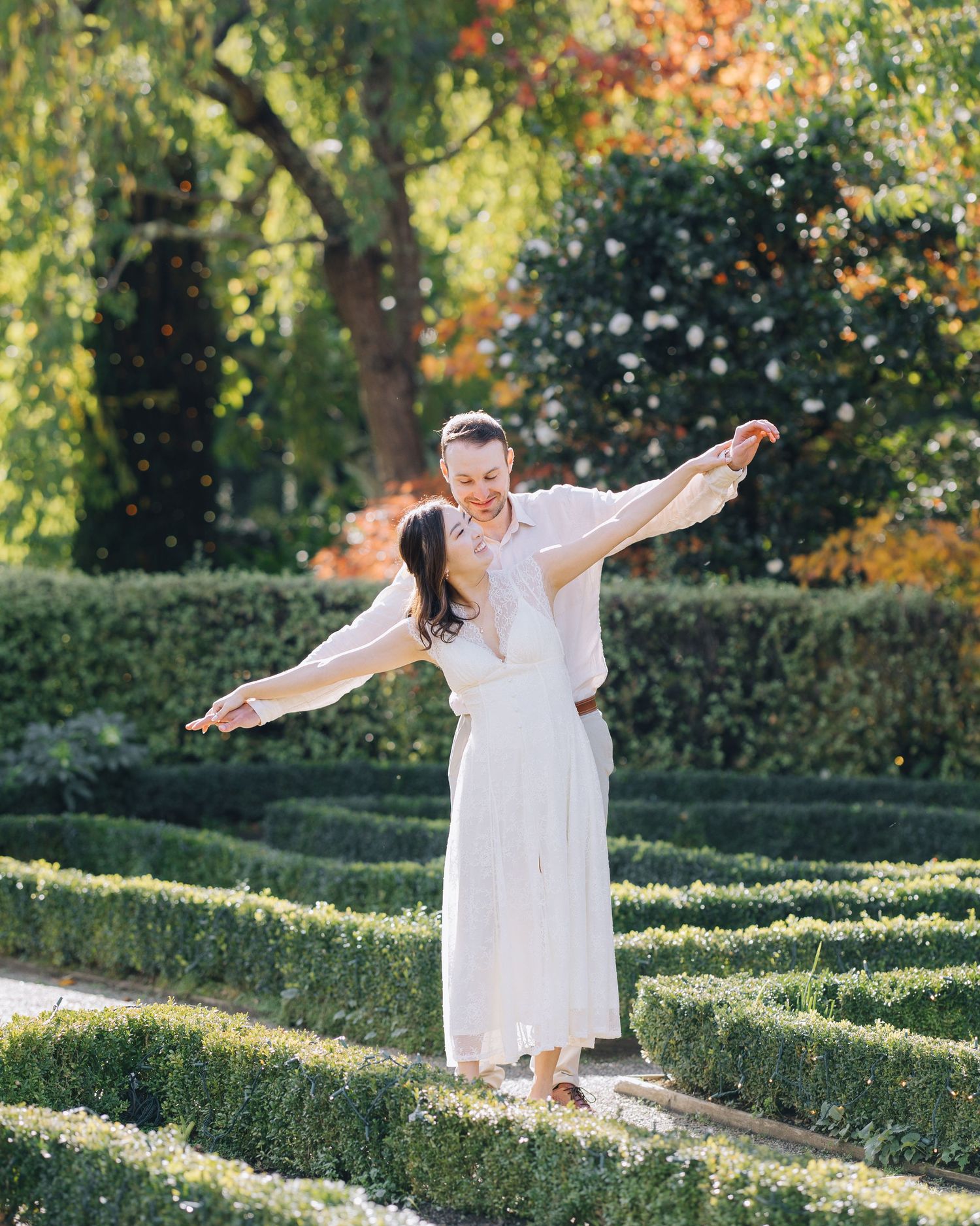 Couple joyfully posing with arms outstretched during engagement session at Filoli in Woodside CA.